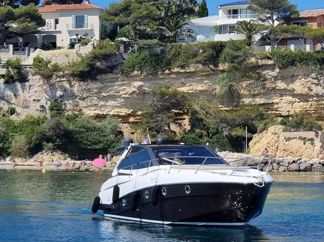 Rio Yachts Parana 38 — Bateau à moteur blanc et noir vu de trois quarts dans une crique.