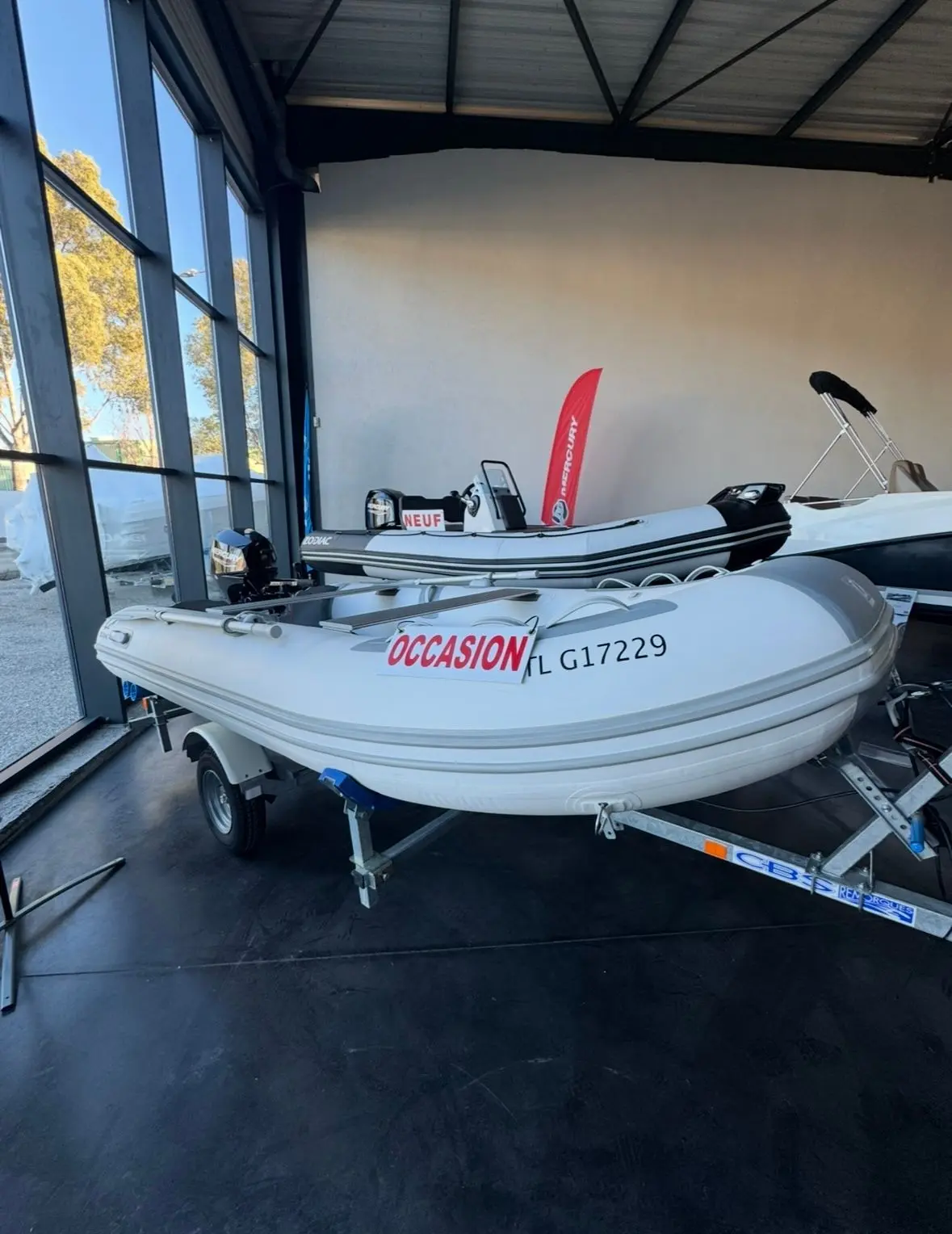 Zodiac Cadet 350 Alu — Bateau pneumatique blanc exposé sur remorque dans un espace intérieur.