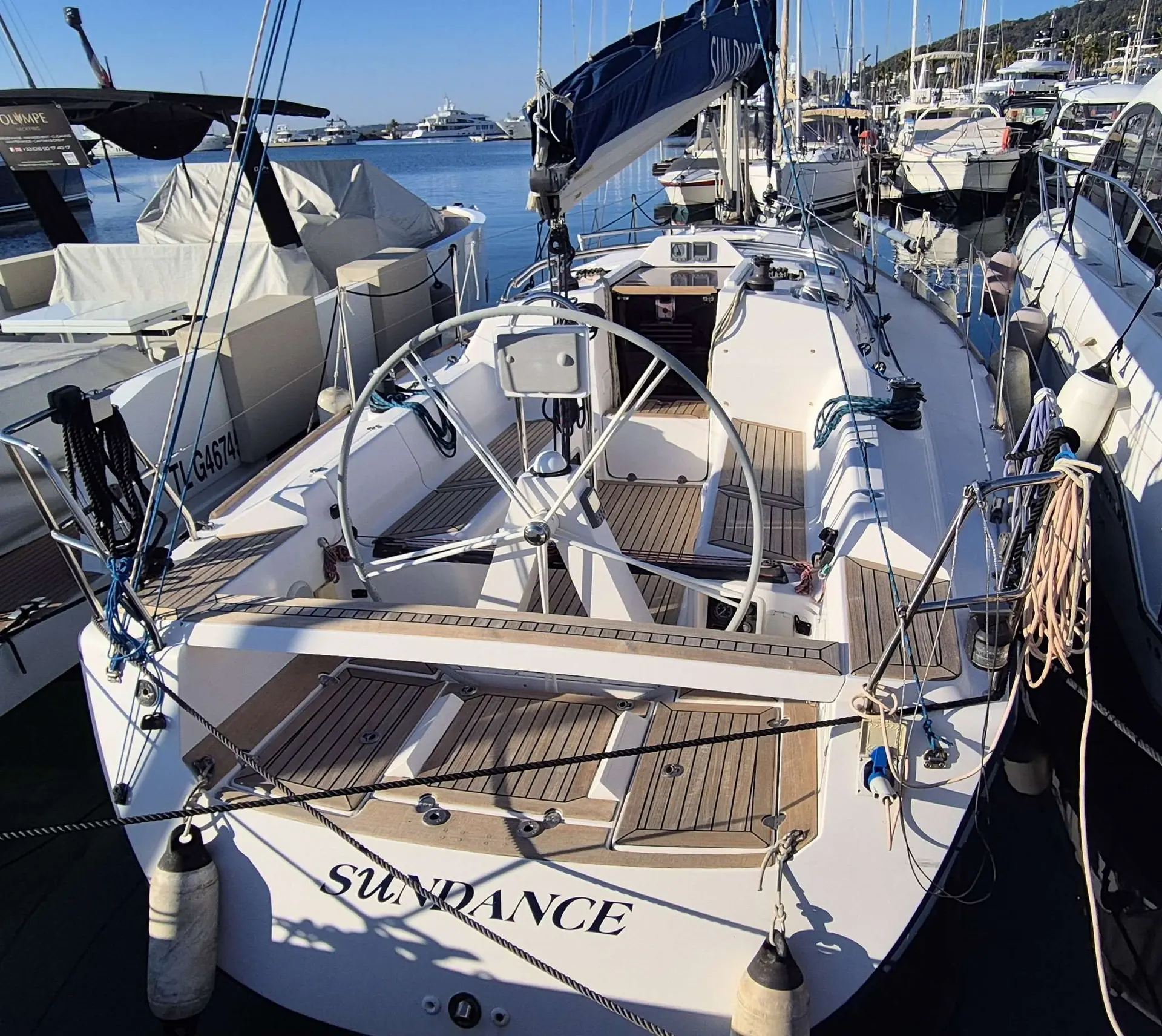 Elan 340 — Vue arrière du cockpit et du pont d’un voilier amarré dans une marina.