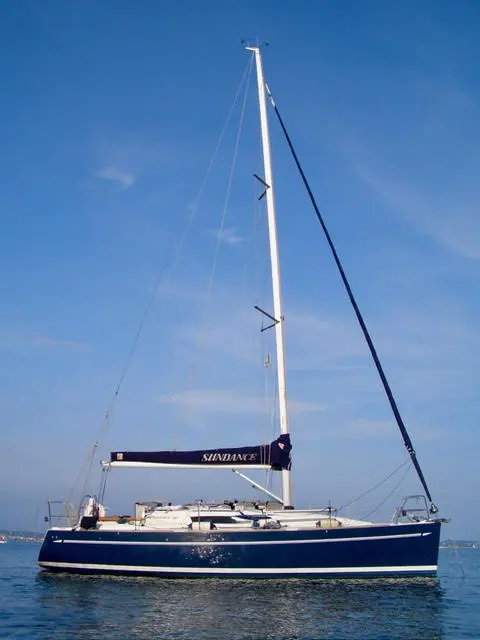 Elan 340 — Voilier bleu et blanc vu de profil sur l’eau, avec son mât et ses gréements.