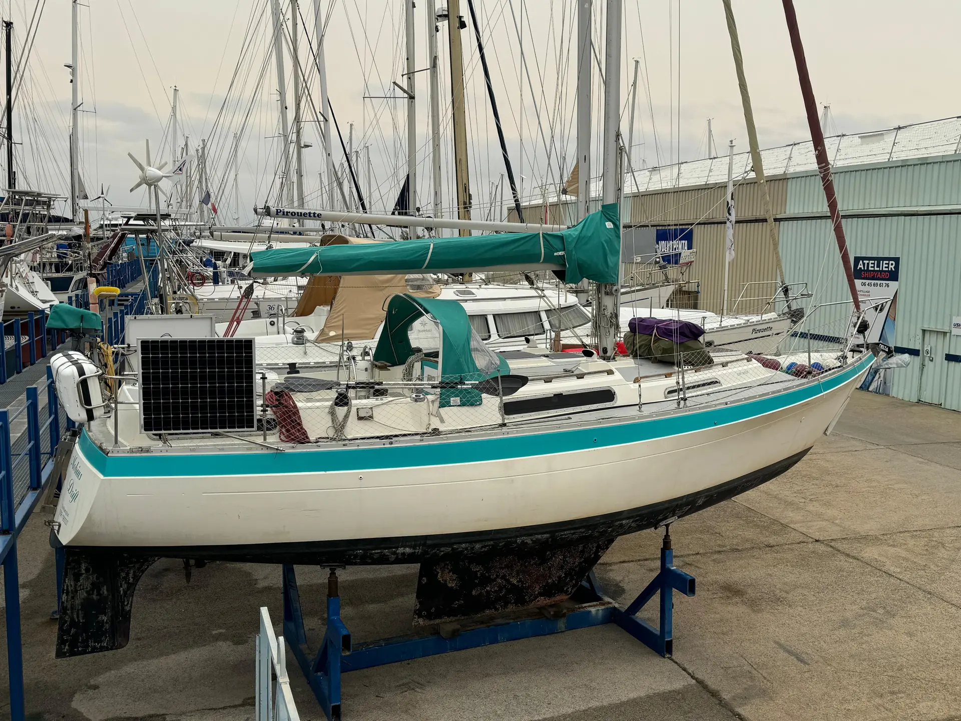 Moody 33 — Voilier vu de trois-quarts arrière, présenté à terre sur bers dans un chantier naval.