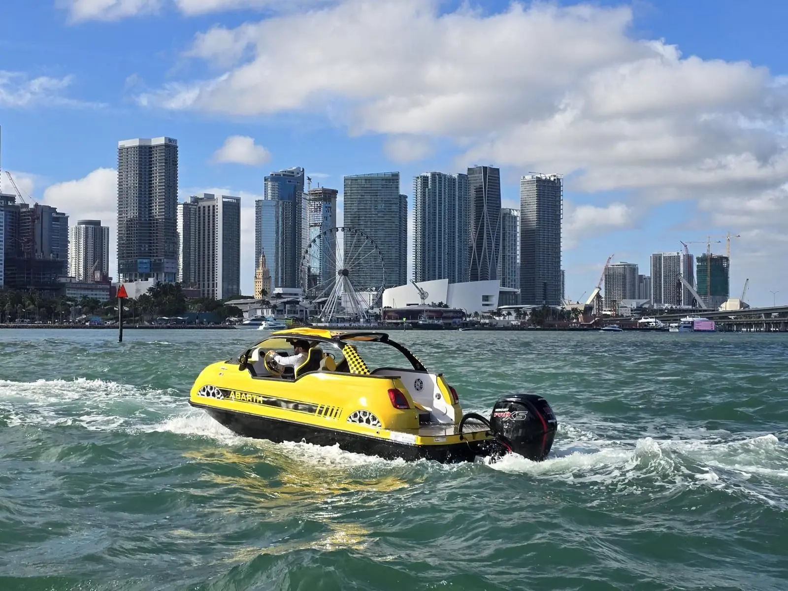 Offshore Passion FIAT 500 ABARTH — Bateau pneumatique jaune naviguant devant une skyline urbaine.