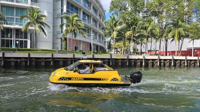 Offshore Passion FIAT 500 ABARTH — Bateau jaune à moteur hors-bord naviguant devant des immeubles au bord de l’eau.