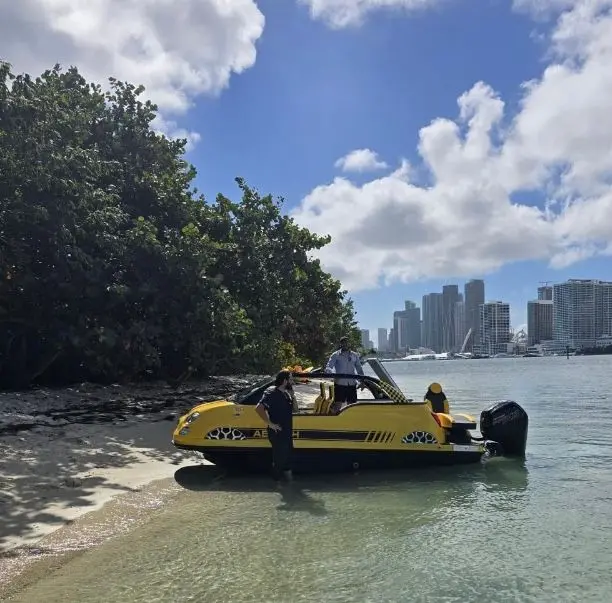 Offshore Passion FIAT 500 ABARTH — Bateau jaune échoué près d’une rive, avec deux personnes à bord.