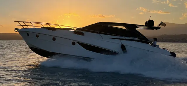 Rio Parana 38 — Bateau à moteur naviguant au large au coucher du soleil.