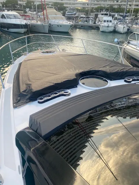 Rio Parana 38 — Vue de l’avant d’un bateau à moteur amarré dans une marina, avec taud de protection.
