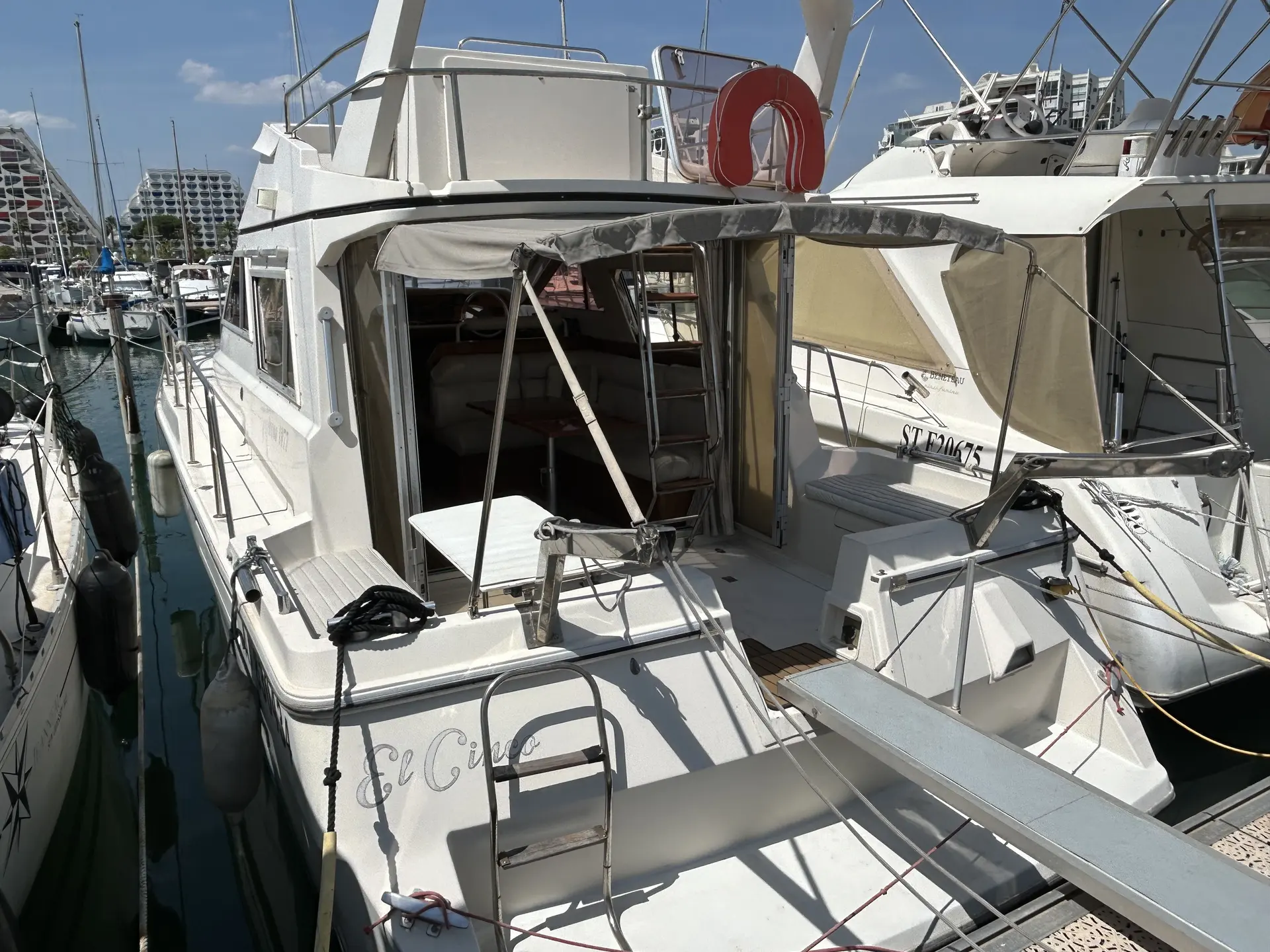 Arcoa 1077 — Vue arrière d’un bateau à moteur amarré dans une marina.