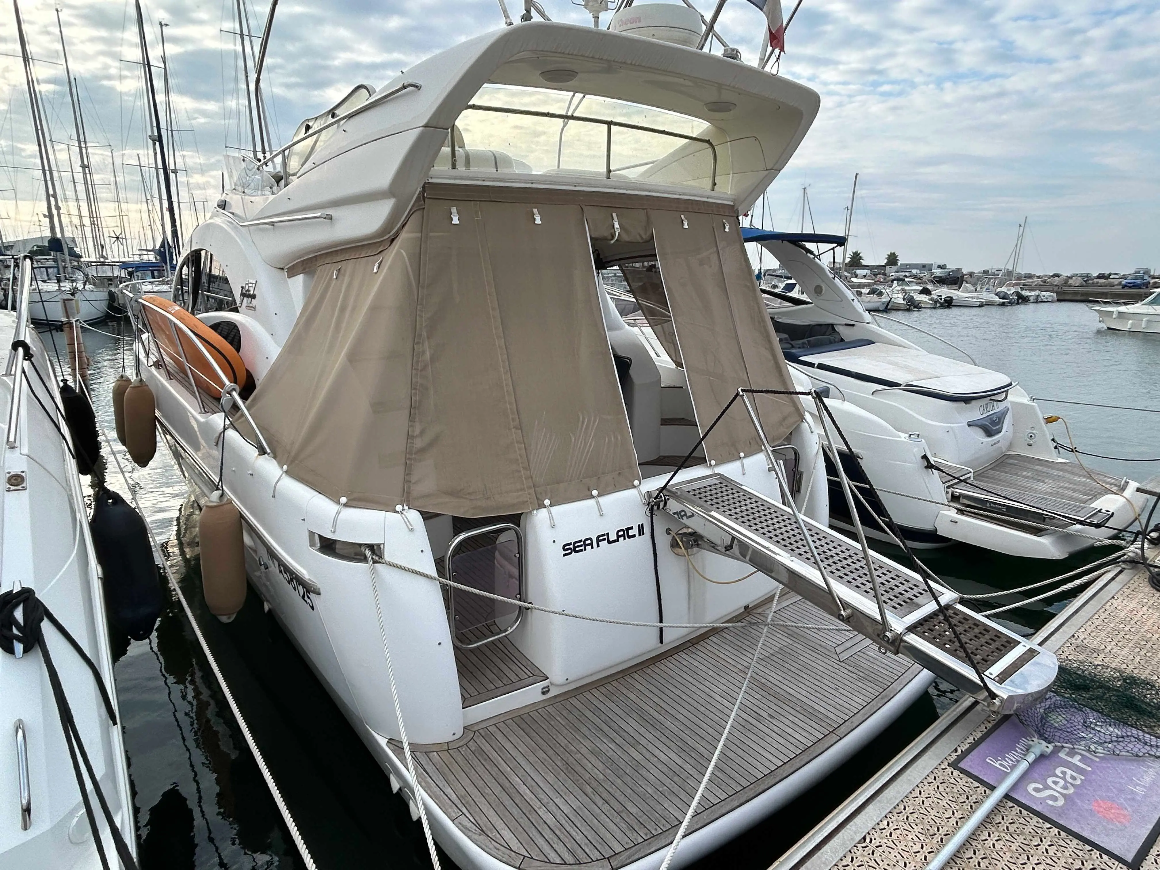 Azimut 39 — Vue arrière trois quarts d’un bateau à moteur amarré dans une marina.