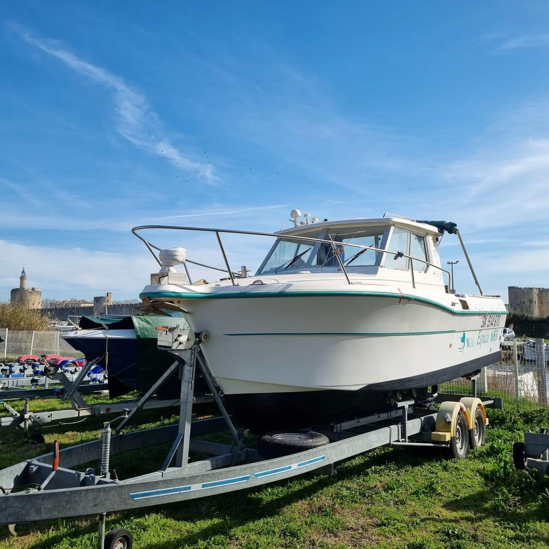 Ocqueteau 685 — Bateau à cabine présenté sur sa remorque, photographié de trois quarts avant.