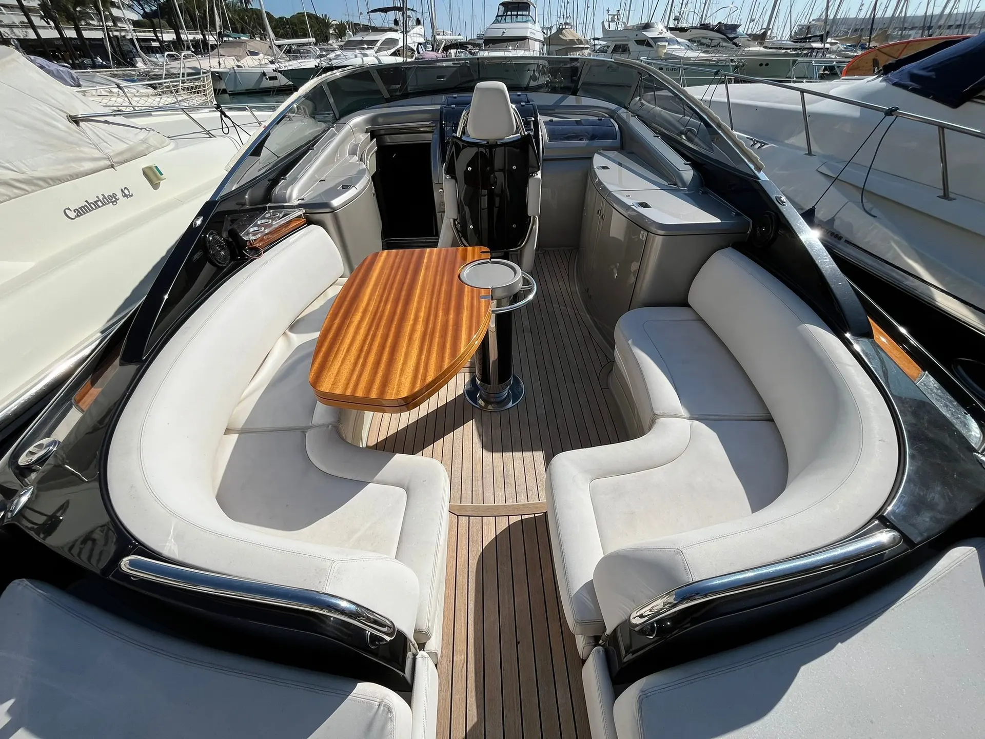 Riva Rivarama 44 — Vue du cockpit extérieur avec banquettes, table et poste de pilotage.