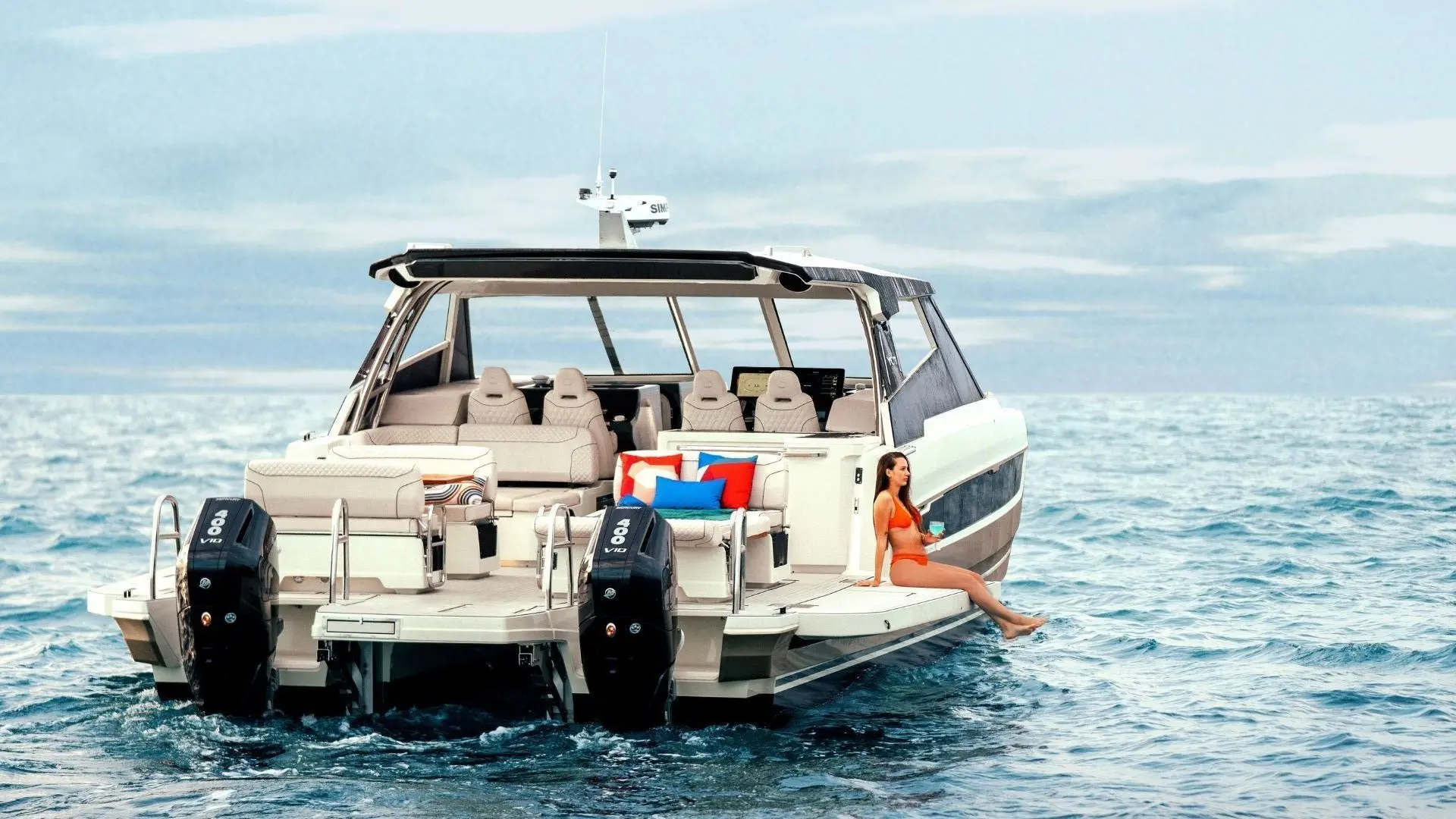 Yot 41 — Bateau à moteur vu de l’arrière sur mer, avec une personne assise à tribord.