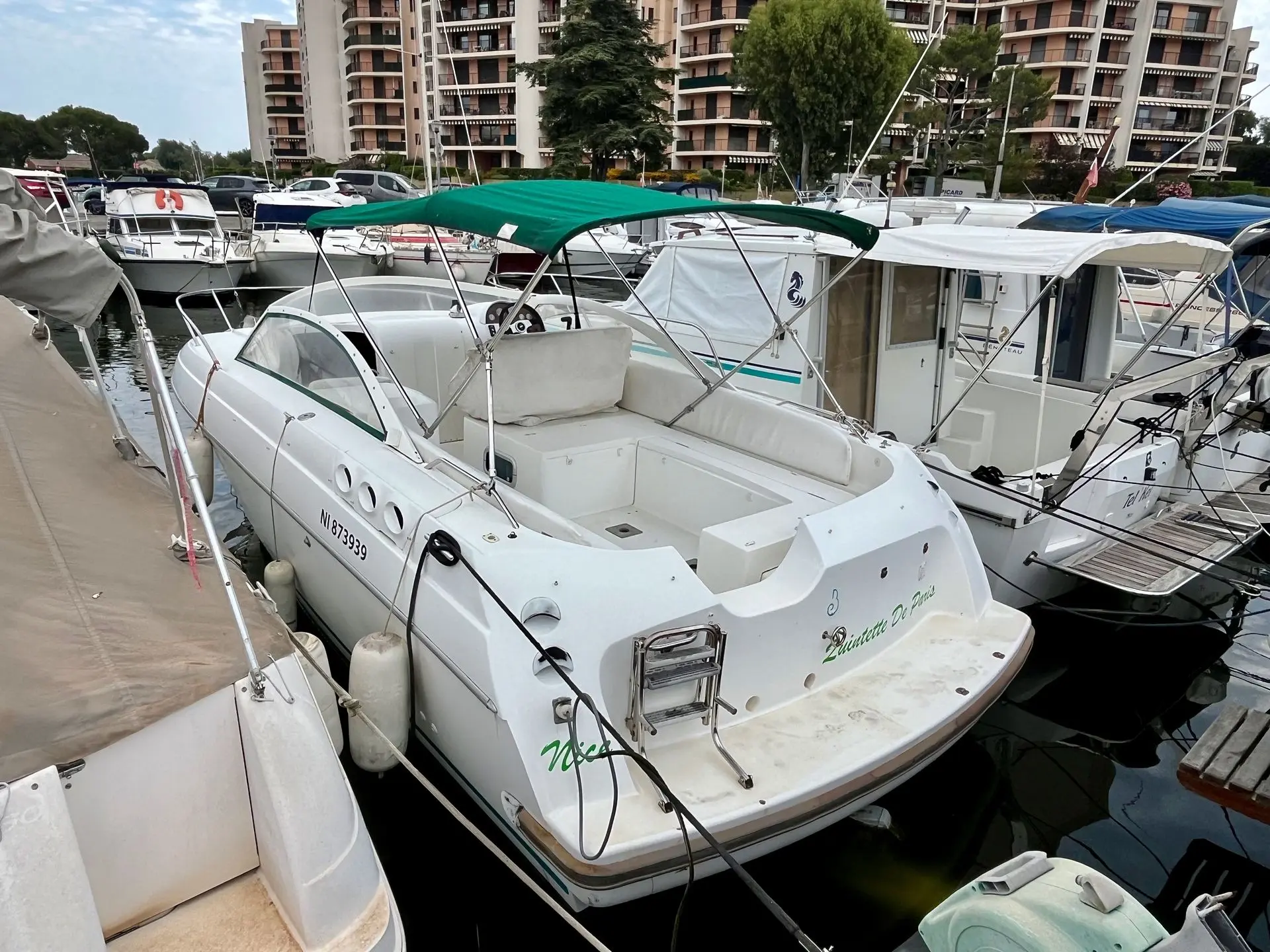 Beneteau Flyer 780 — Bateau à moteur blanc amarré, vu de trois quarts arrière dans un port.