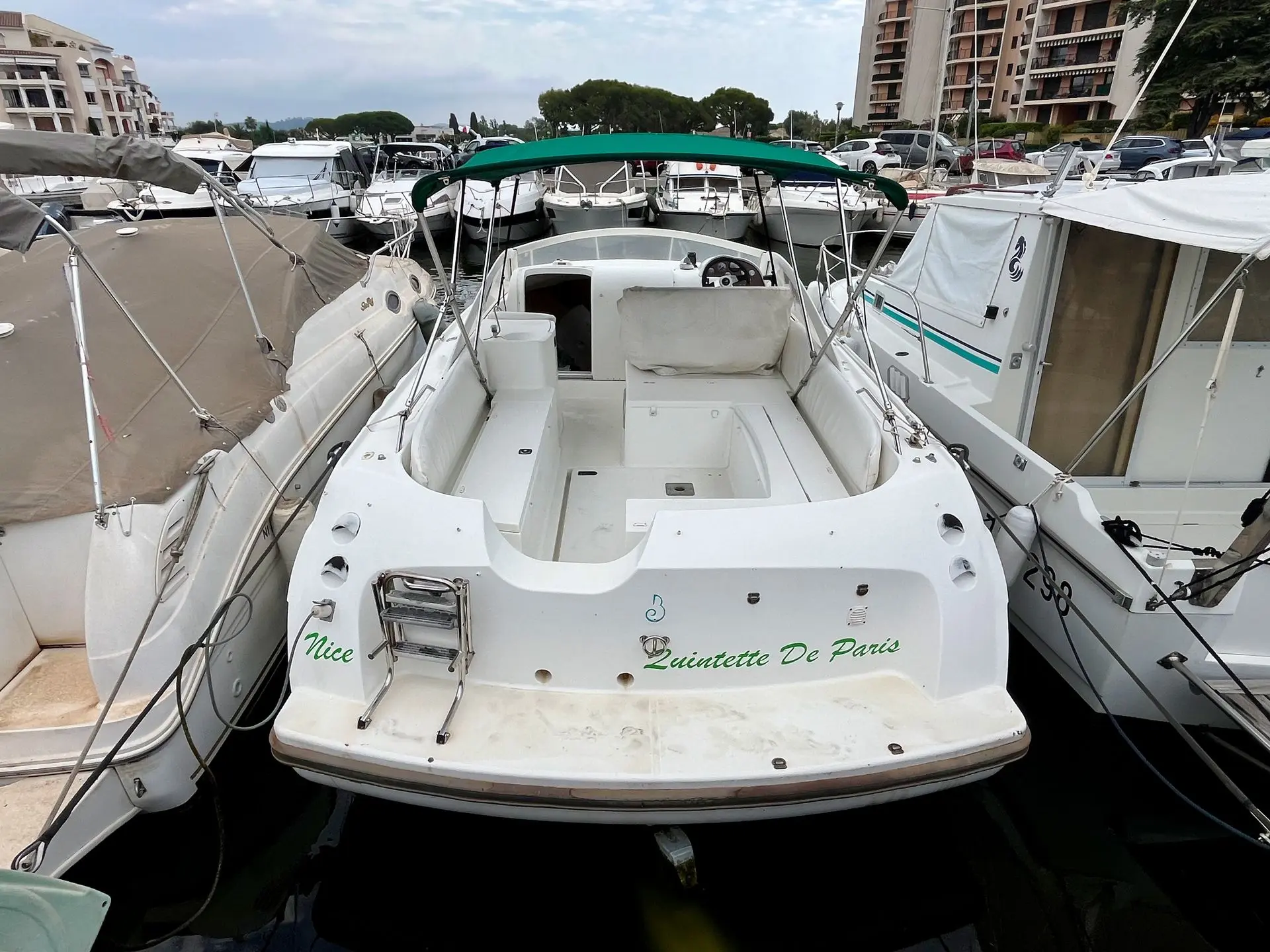 Beneteau Flyer 780 — Vue arrière d’un bateau blanc amarré dans un port, avec cockpit et cabine visibles.