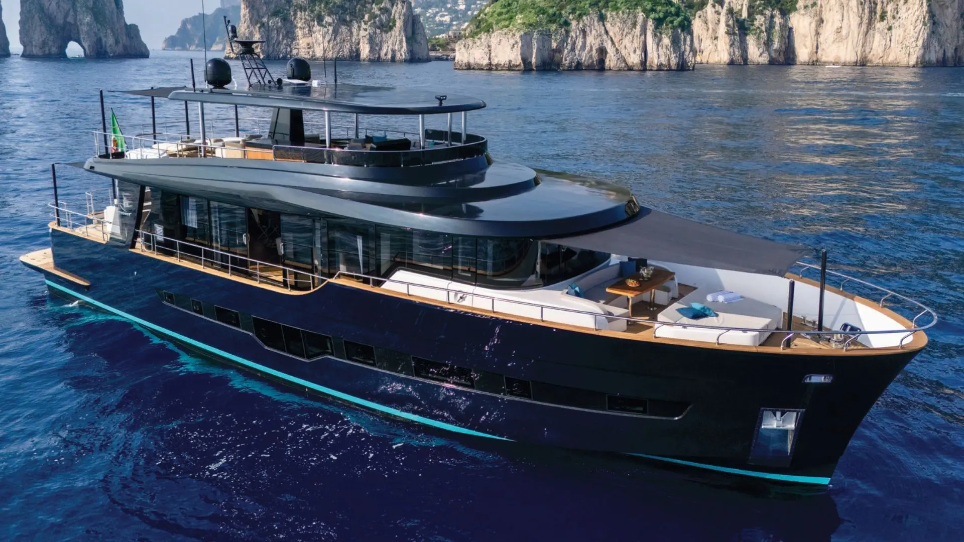 Apreamare MAESTRO 88 — Yacht vu de trois quarts bâbord, naviguant devant des falaises côtières.
