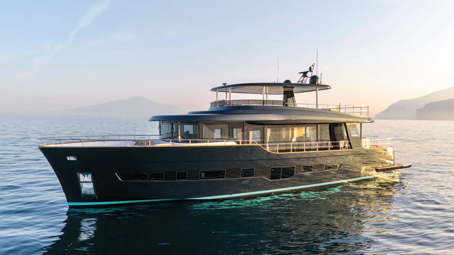 Apreamare MAESTRO 88 — Bateau à moteur sombre vu de trois quarts sur une mer calme au coucher du soleil.