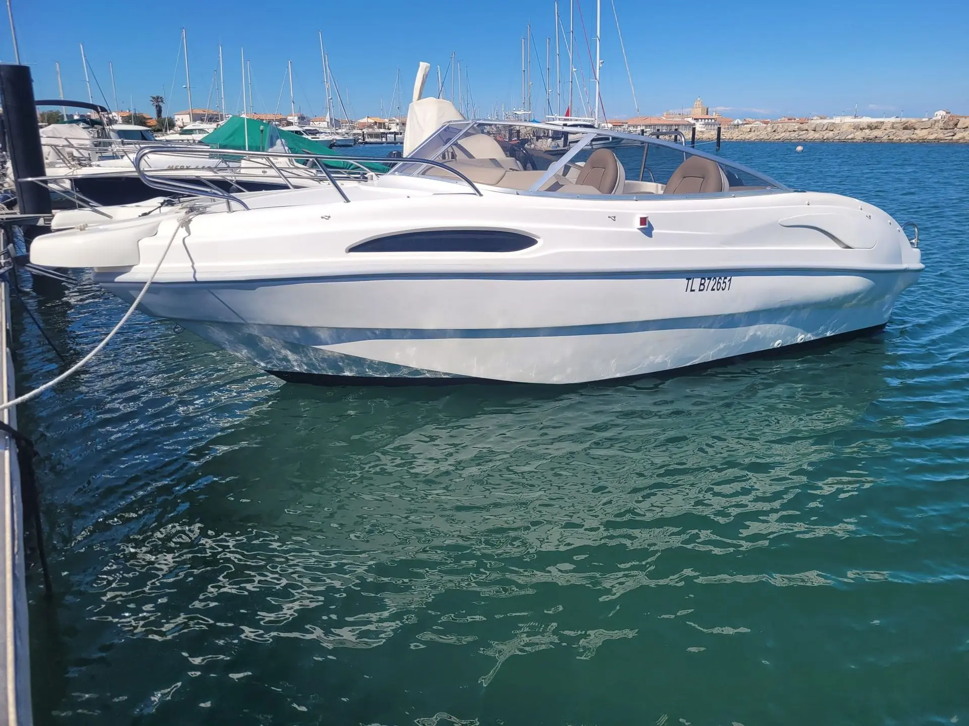 Rio 550 Cruiser — Bateau à moteur blanc vu de profil, amarré dans un port de plaisance.
