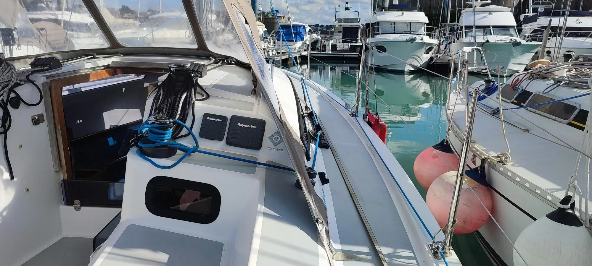 RM Yachts RM 890 — Vue partielle du cockpit et du passavant d’un voilier amarré au port.