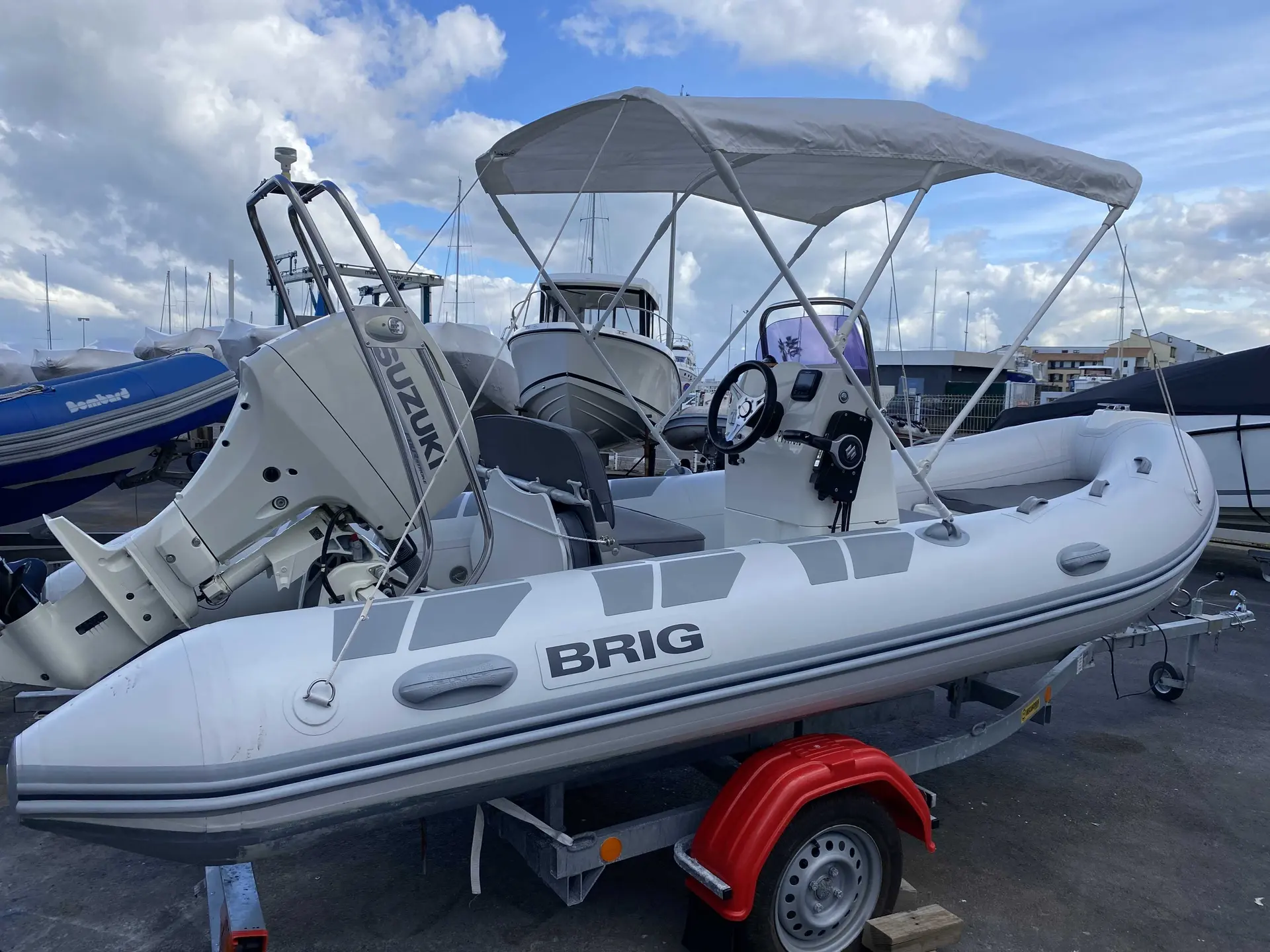 Brig Falcon 450 — Bateau pneumatique blanc sur remorque, équipé d’un taud et d’un moteur hors-bord.
