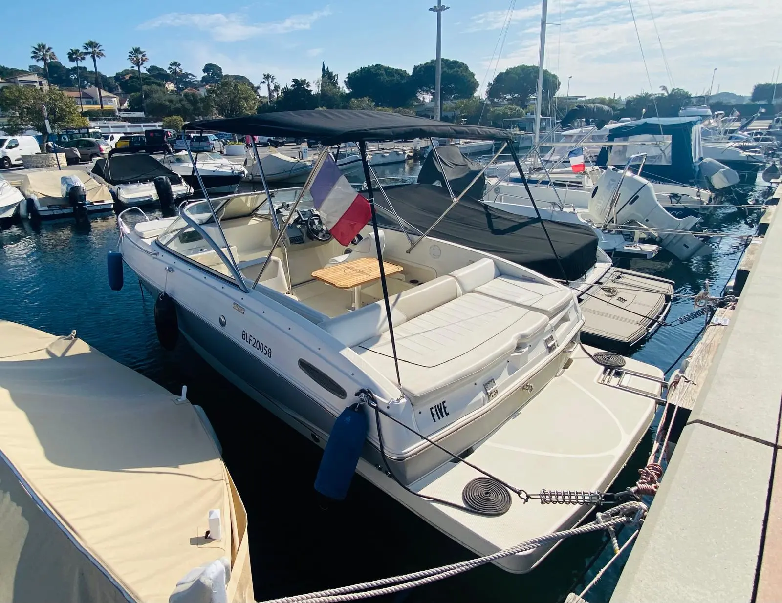 Bayliner 642 CU — Bateau à moteur amarré dans une marina, vu de trois quarts arrière.