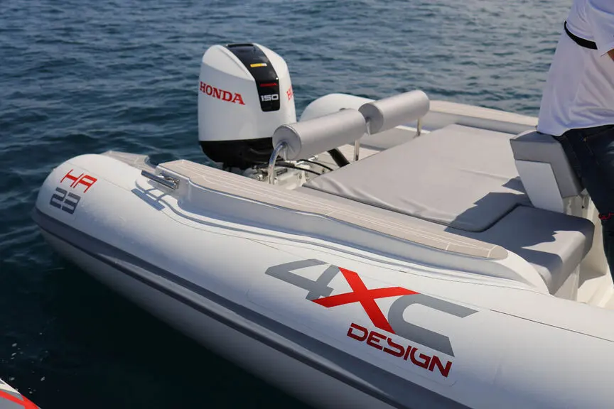 4XC HA23 — Vue rapprochée de l’arrière d’un bateau semi-rigide avec moteur hors-bord.