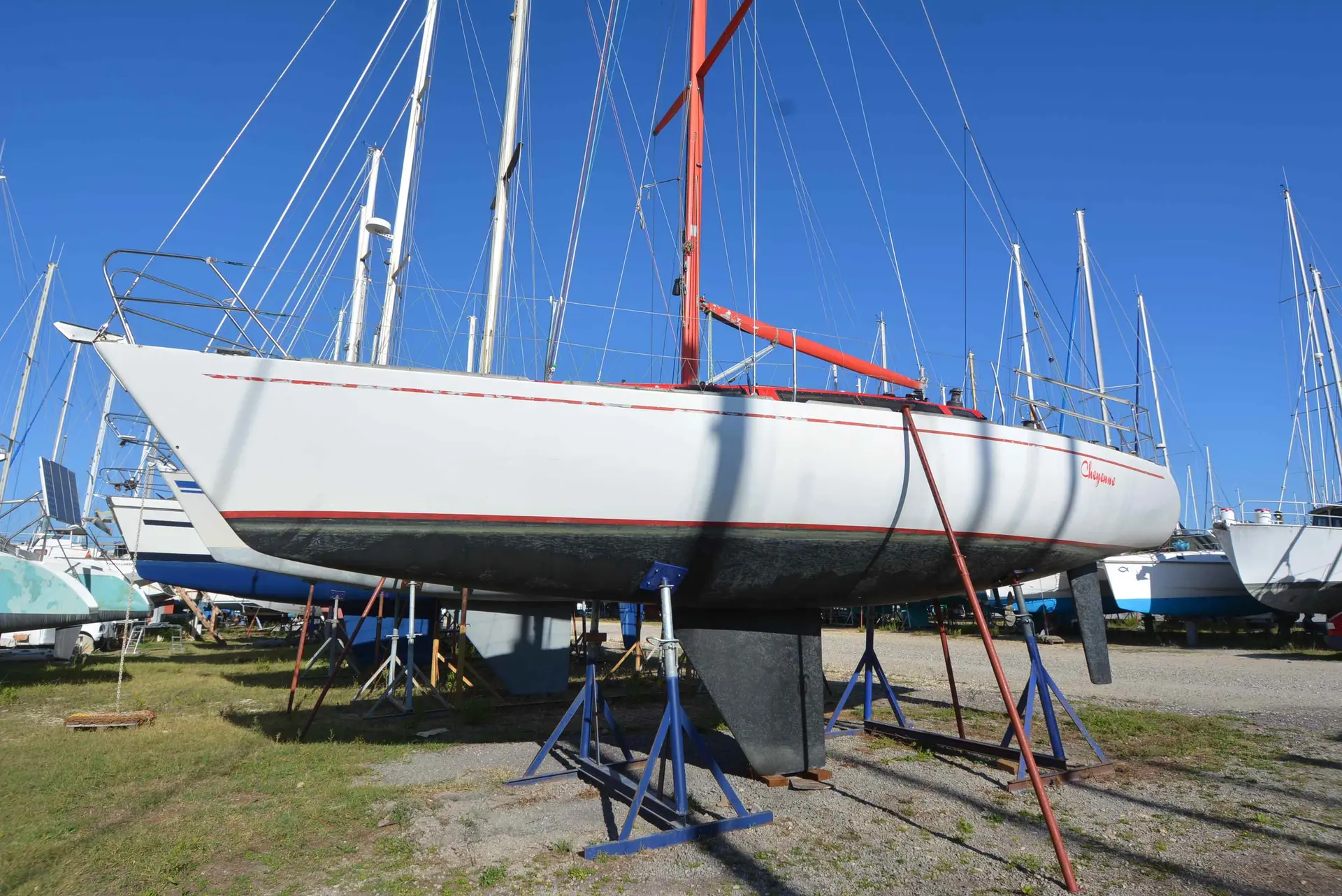 Fountaine Pajot Prototype One Tonner — Voilier blanc à liserés rouges posé sur bers dans un chantier naval.