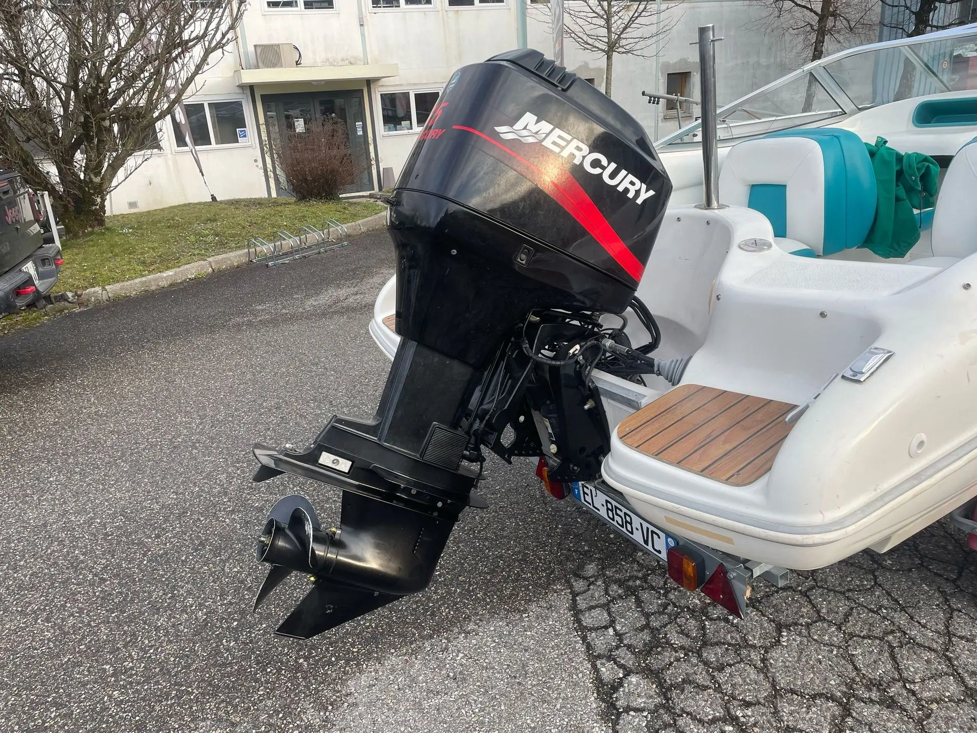Quicksilver 470 Sport — Vue arrière d’un bateau avec moteur hors-bord et plateforme arrière.