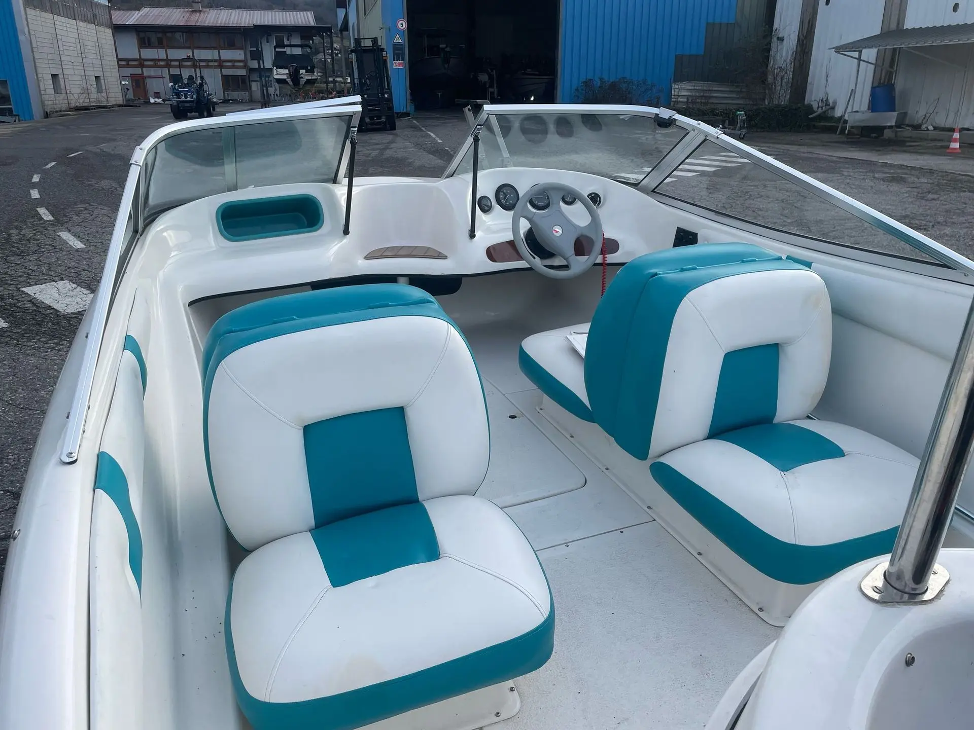 Quicksilver 470 Sport — Vue du cockpit avec sièges, pare-brise et poste de pilotage.