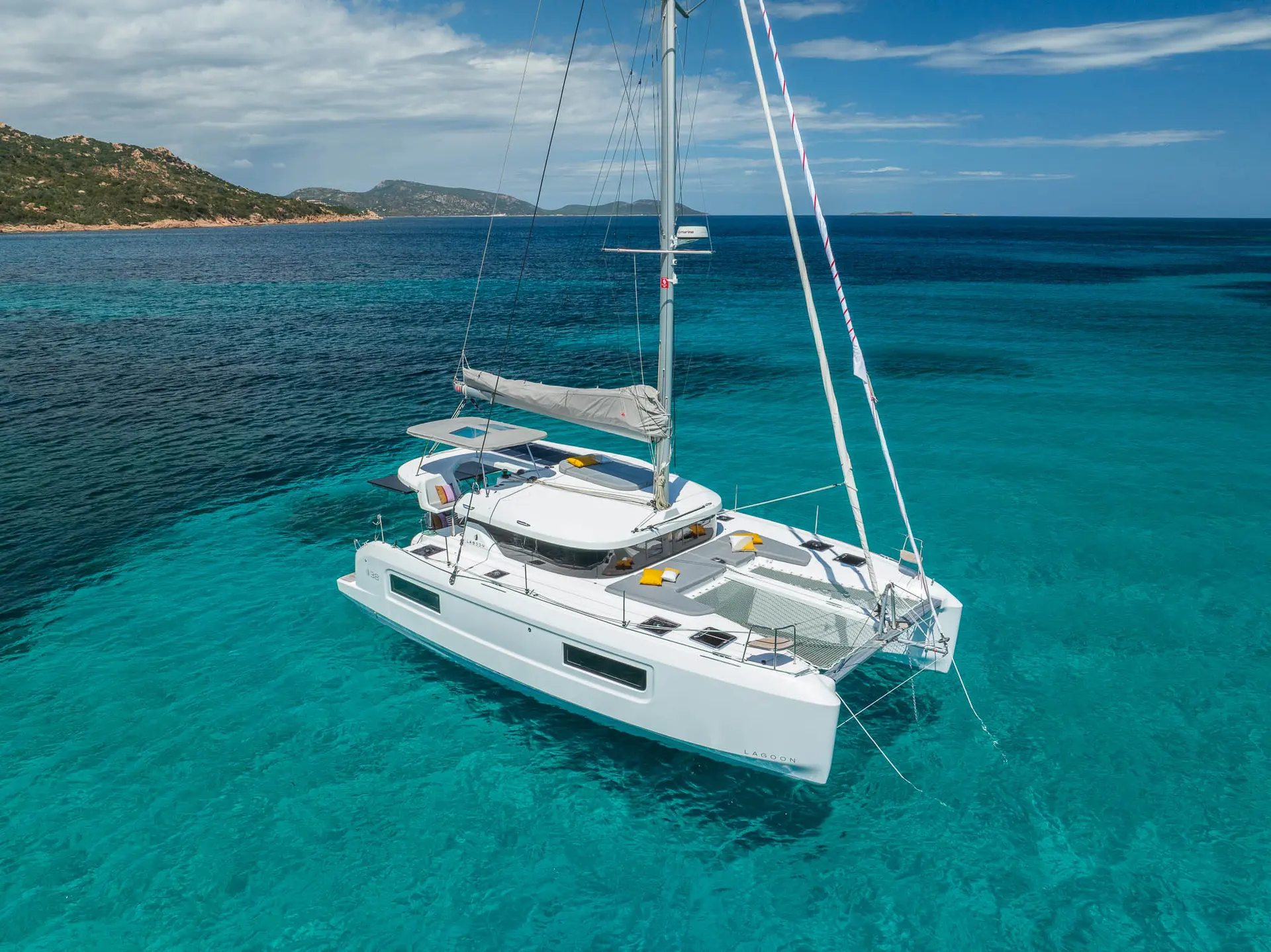 Lagoon 38 — Catamaran blanc vu en trois-quarts au mouillage dans une eau turquoise.