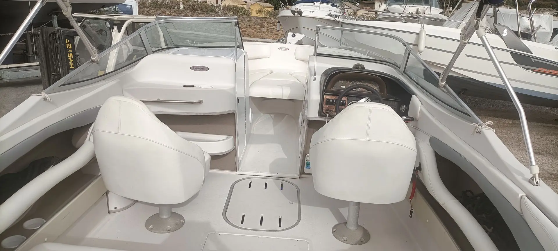 Four Winns Horizon 240 — Vue du cockpit avec sièges, pare-brise et tableau de bord.