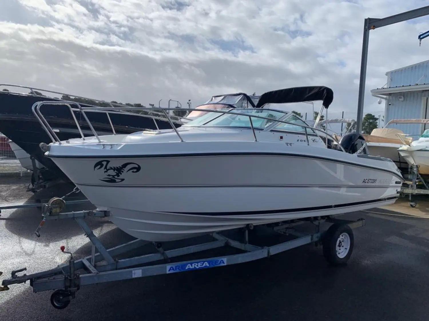Karnic Bluewater 2050 — Bateau à moteur blanc à cabine, photographié de profil sur sa remorque.