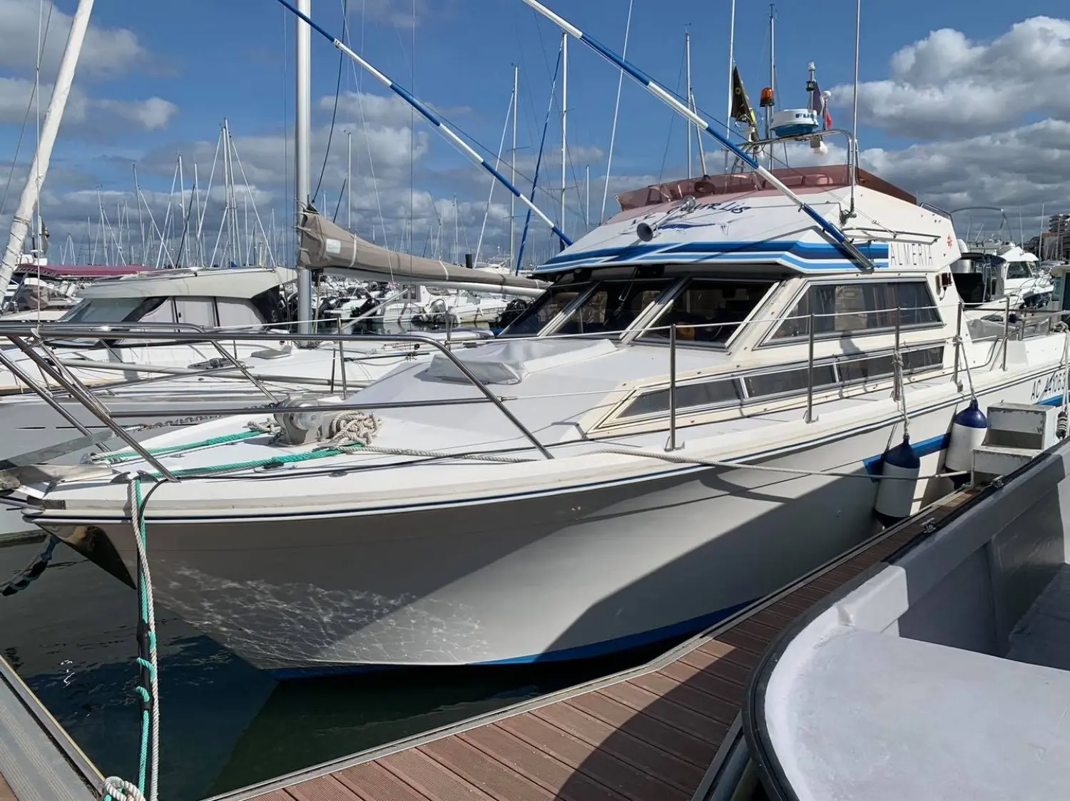 Jeanneau Almeria 960 — Bateau à moteur blanc amarré dans une marina, vu de trois quarts avant.
