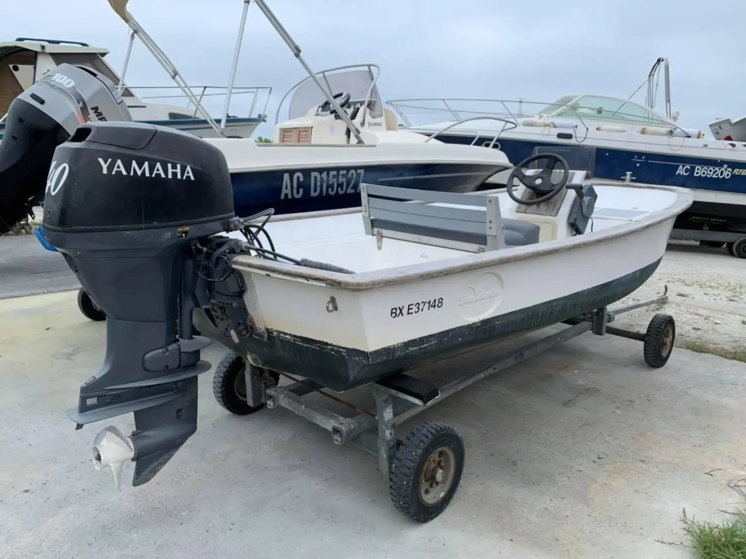 Plate Polyester — Petit bateau blanc sur remorque, équipé d’un moteur hors-bord Yamaha.