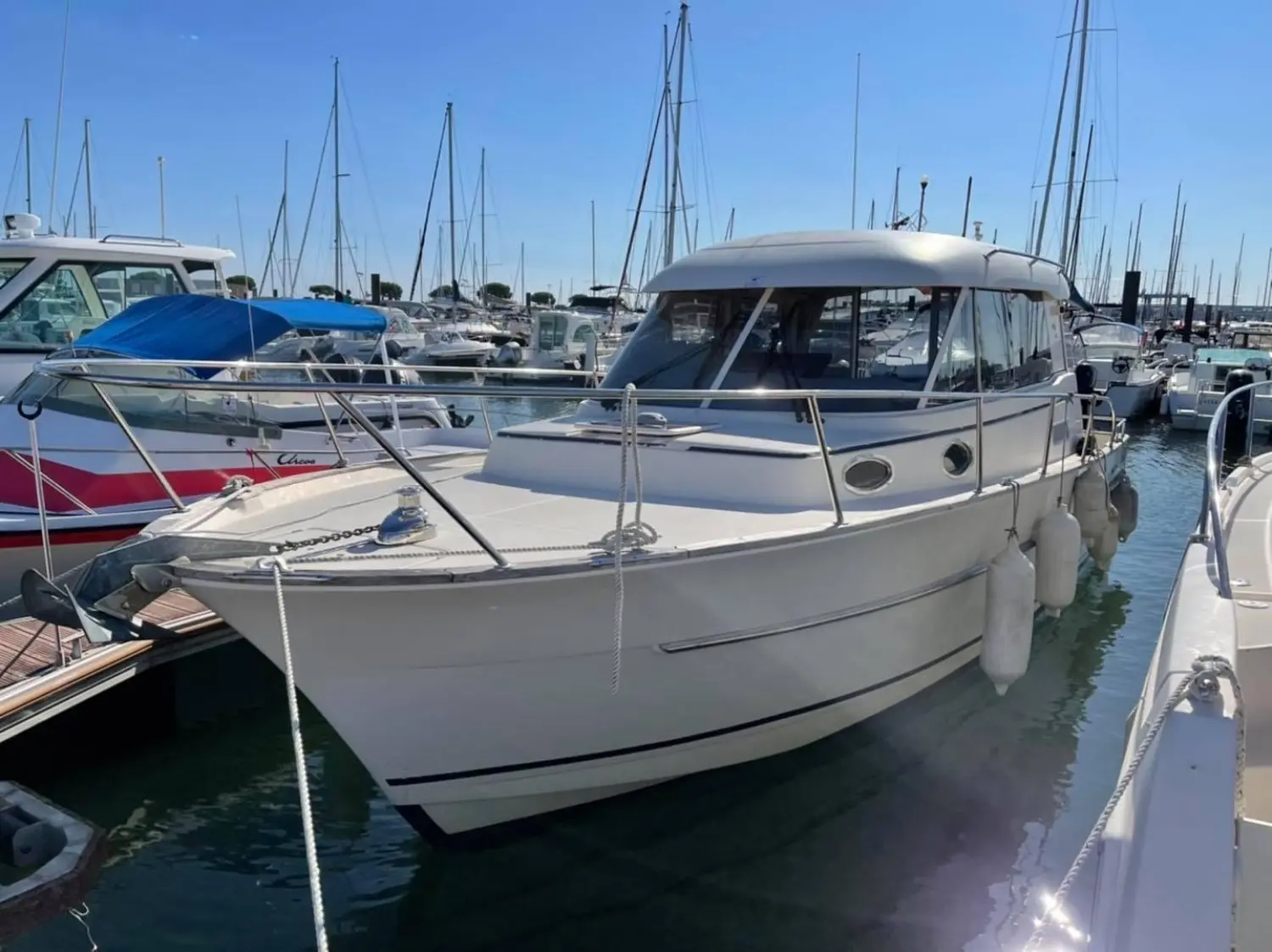 ACM Elite 31 — Bateau à moteur blanc amarré dans une marina, vu de trois quarts avant.