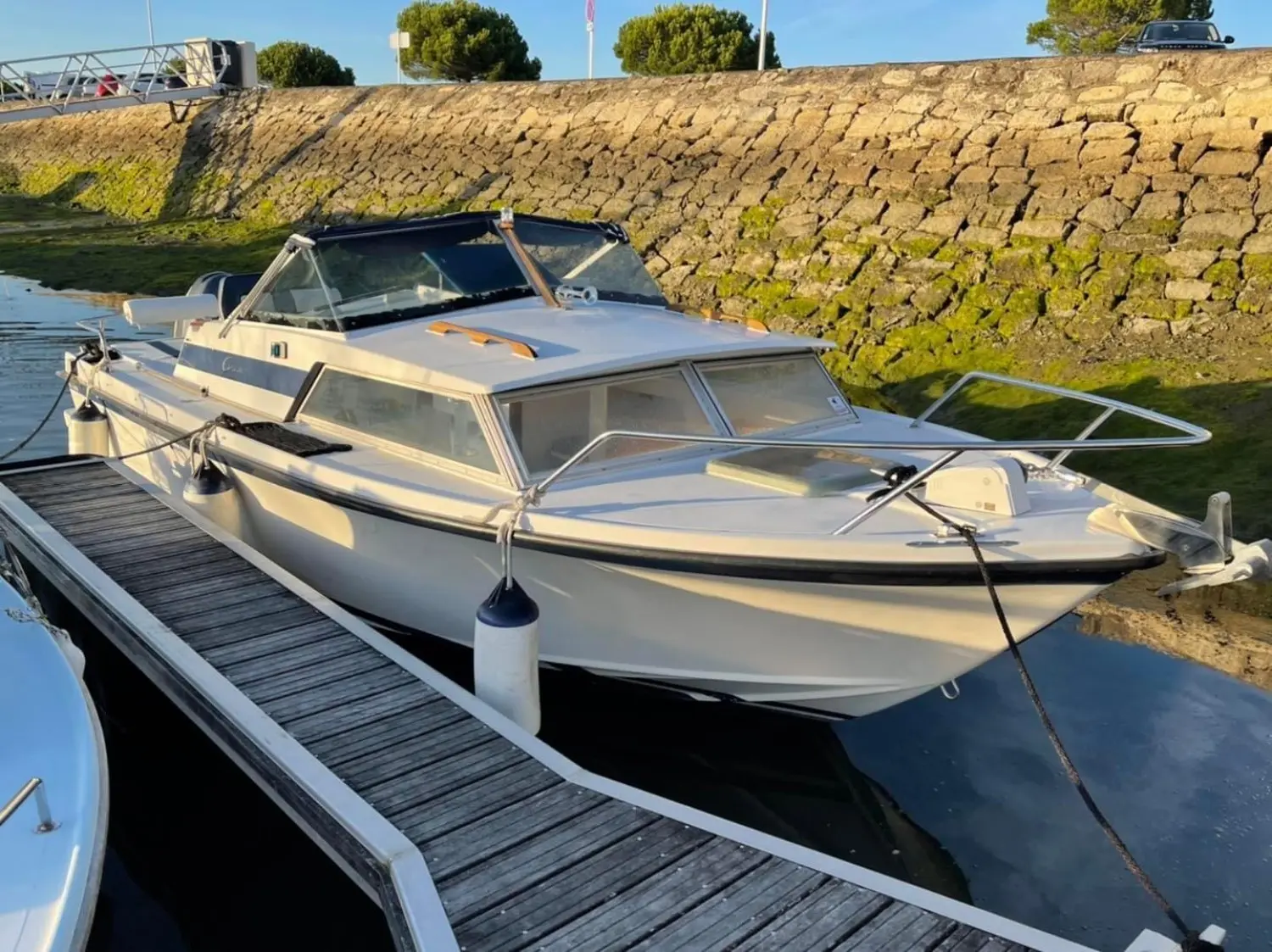 Yachting France Arcoa 680 — Bateau à moteur amarré dans un port, vu de trois quarts avant.