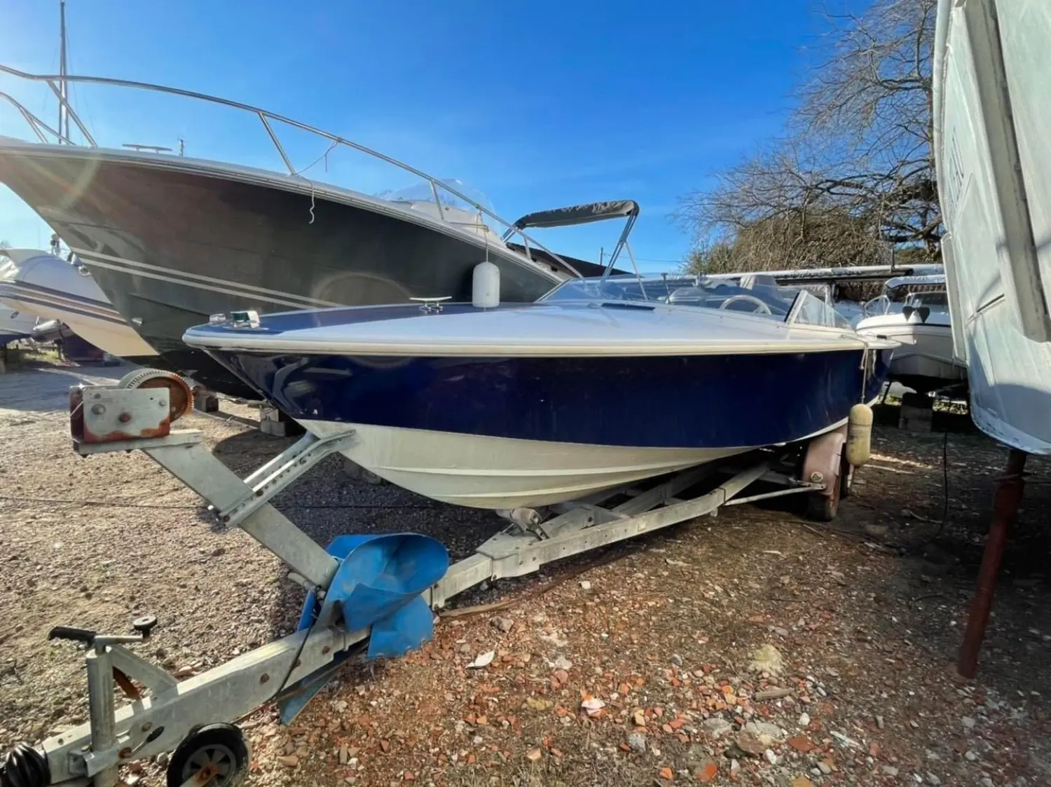 Donzi 21 GT — Bateau à moteur bleu et blanc sur remorque, photographié à terre.