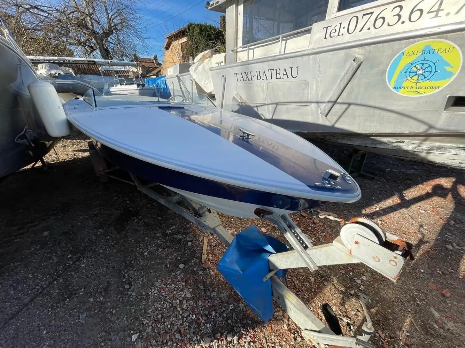 Donzi 21 GT — Bateau à moteur bleu et blanc sur remorque, photographié à terre.
