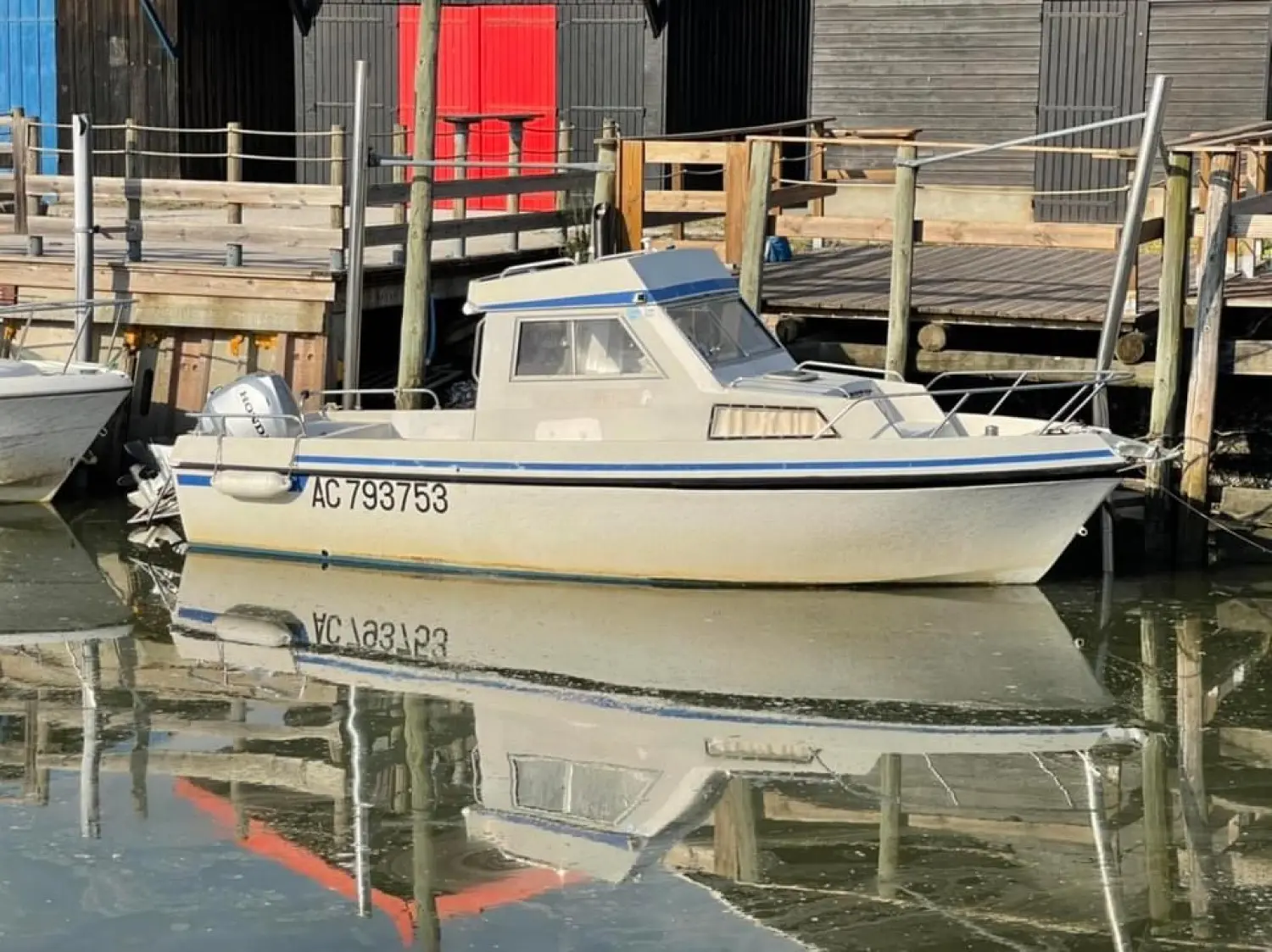 SBPEM S 570 — Bateau à cabine vu de profil, amarré dans un port, avec son immatriculation visible.