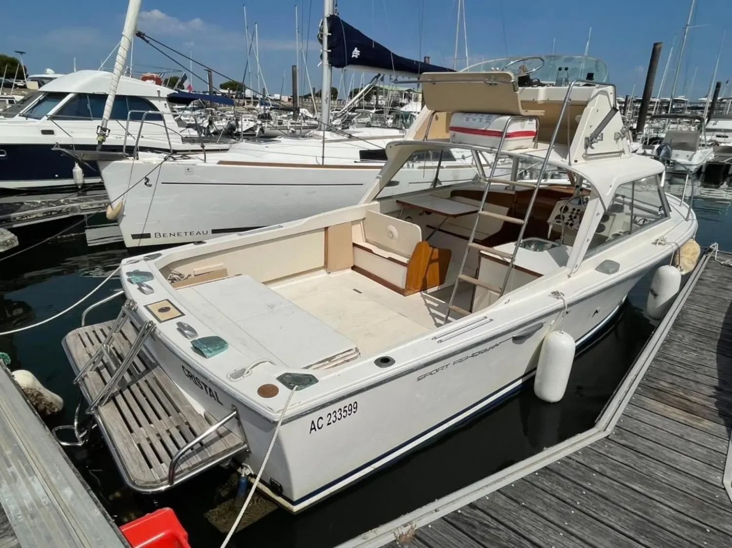 Riva Bertram 25 Sport Fisherman — Bateau à moteur blanc amarré dans une marina, vu de trois quarts arrière.