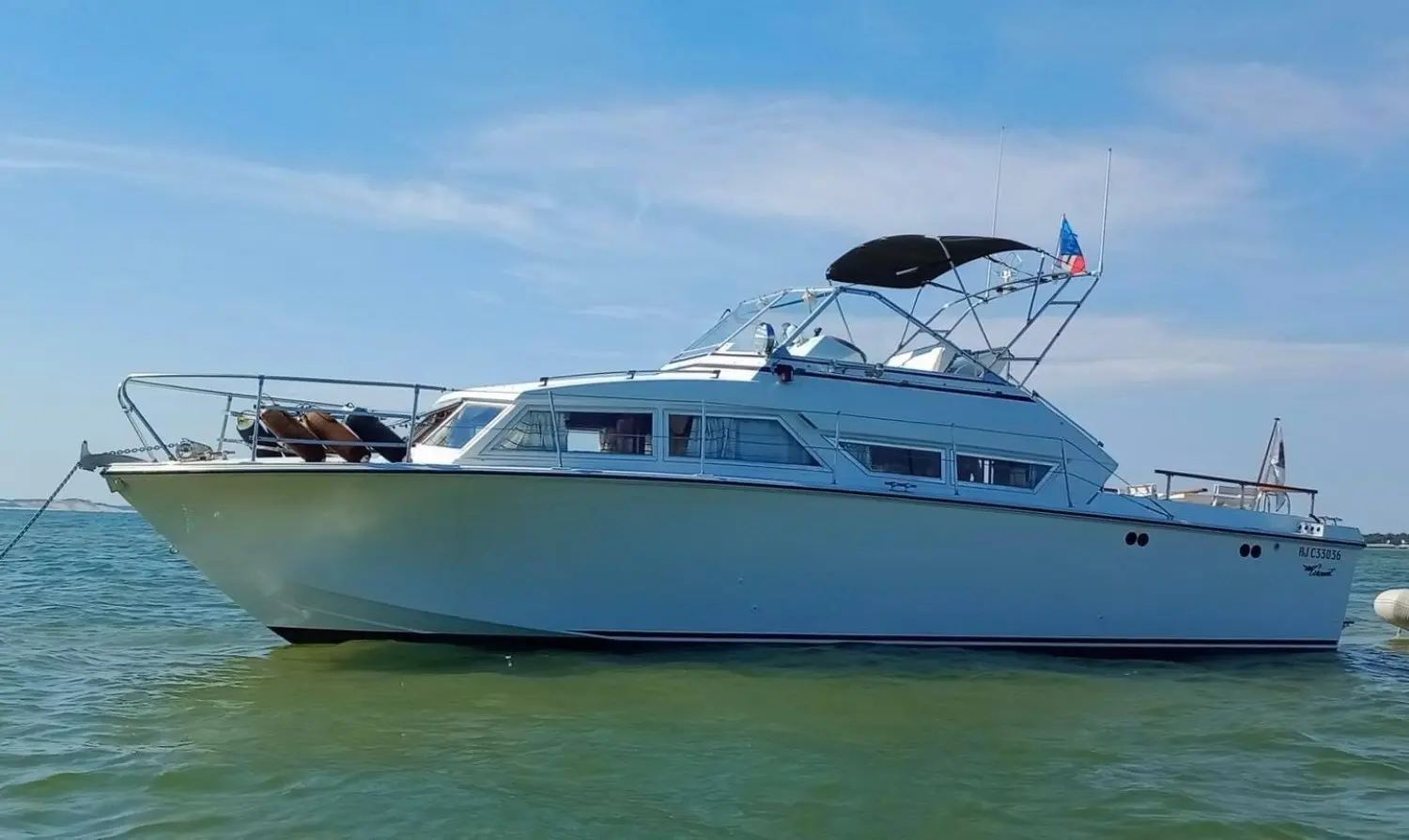 Coronet 32 Oceanfarer — Bateau à moteur blanc photographié de profil sur une mer calme.
