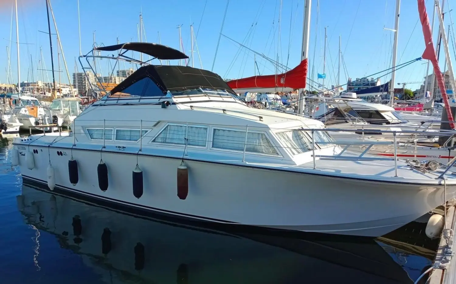 Coronet 32 Oceanfarer — Bateau à moteur blanc amarré dans une marina, vu de trois quarts bâbord.