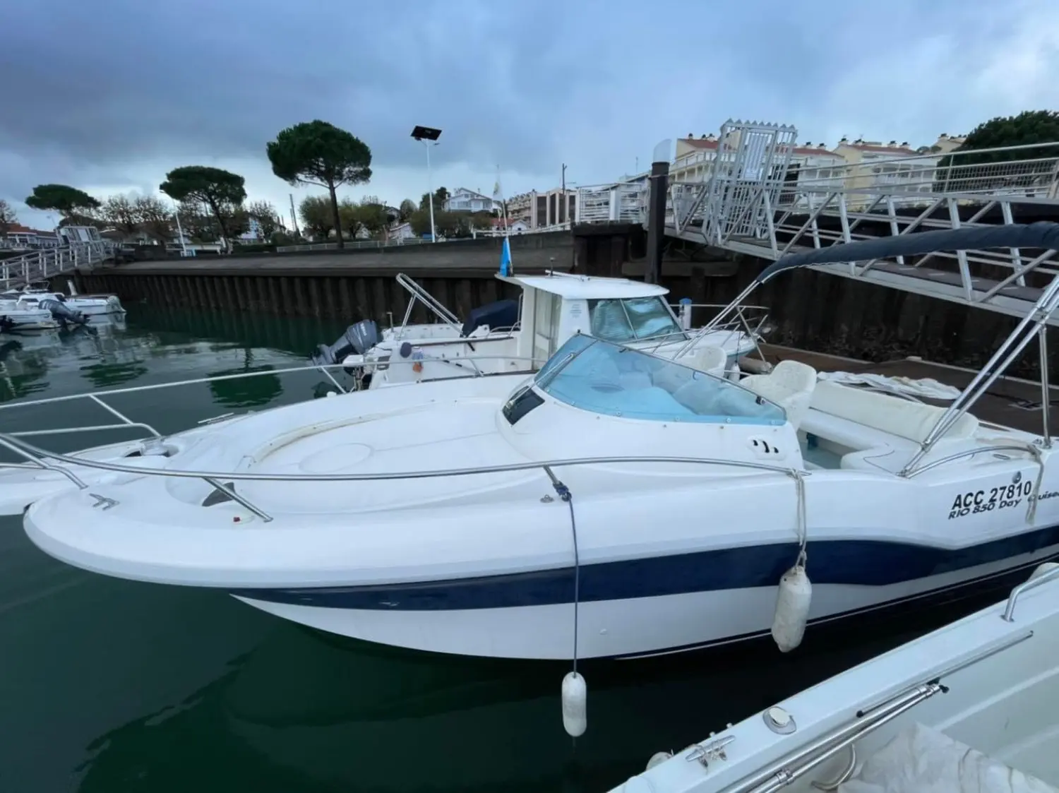 Rio 850 — Bateau à moteur blanc amarré dans un port, vu de trois quarts.