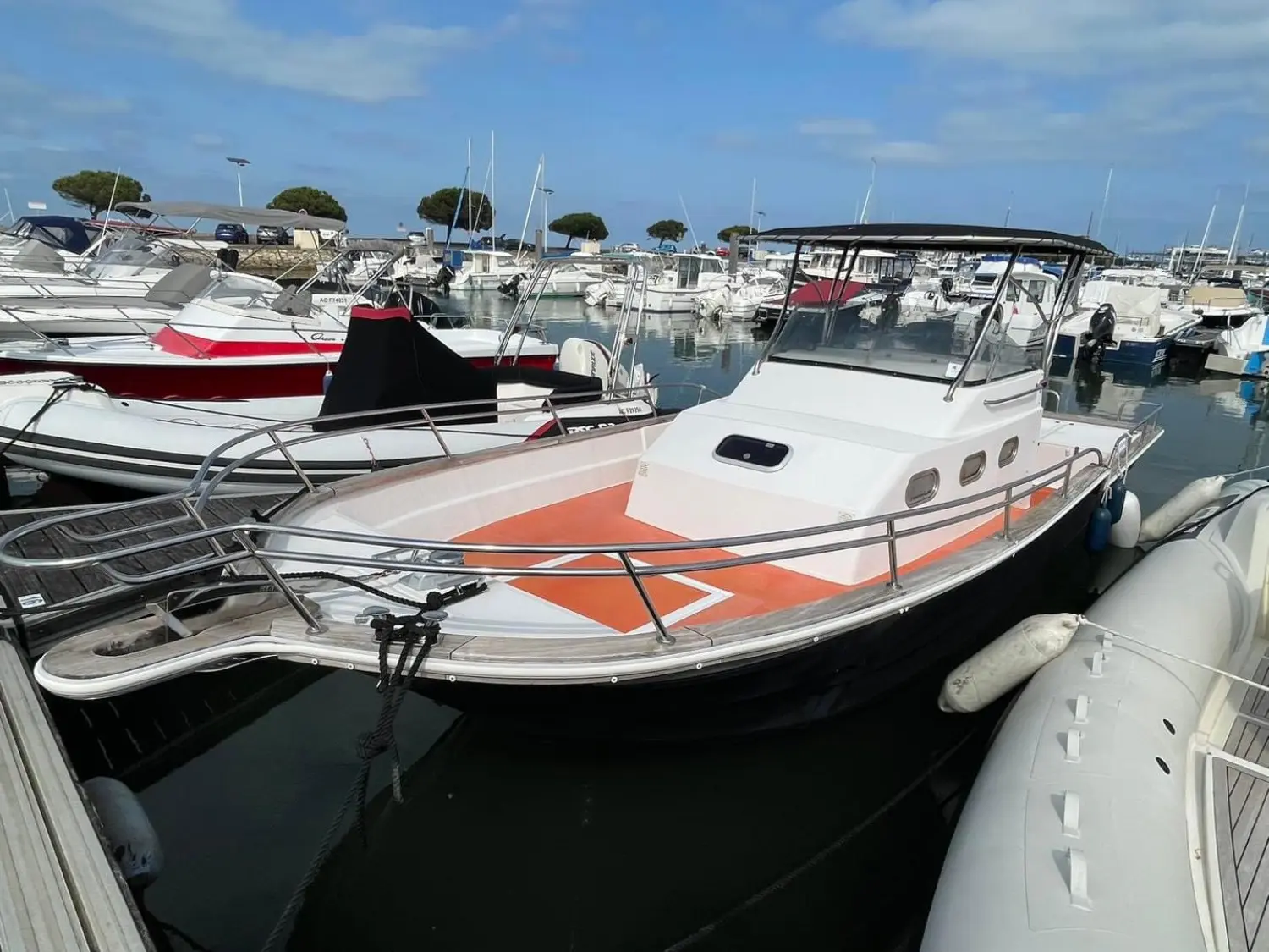 Orka 800 — Bateau à moteur blanc et noir amarré dans un port, vu de trois quarts avant.