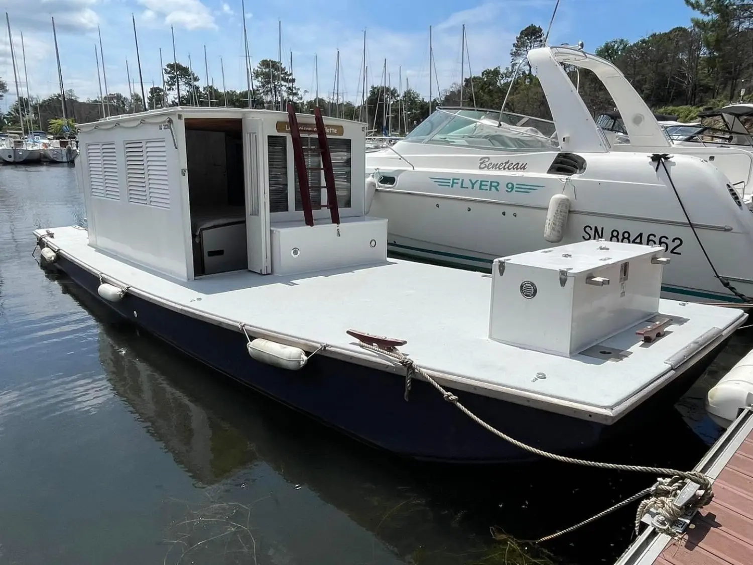Carrere Bac De Plaisance — Bateau blanc à cabine et large pont arrière amarré dans une marina.