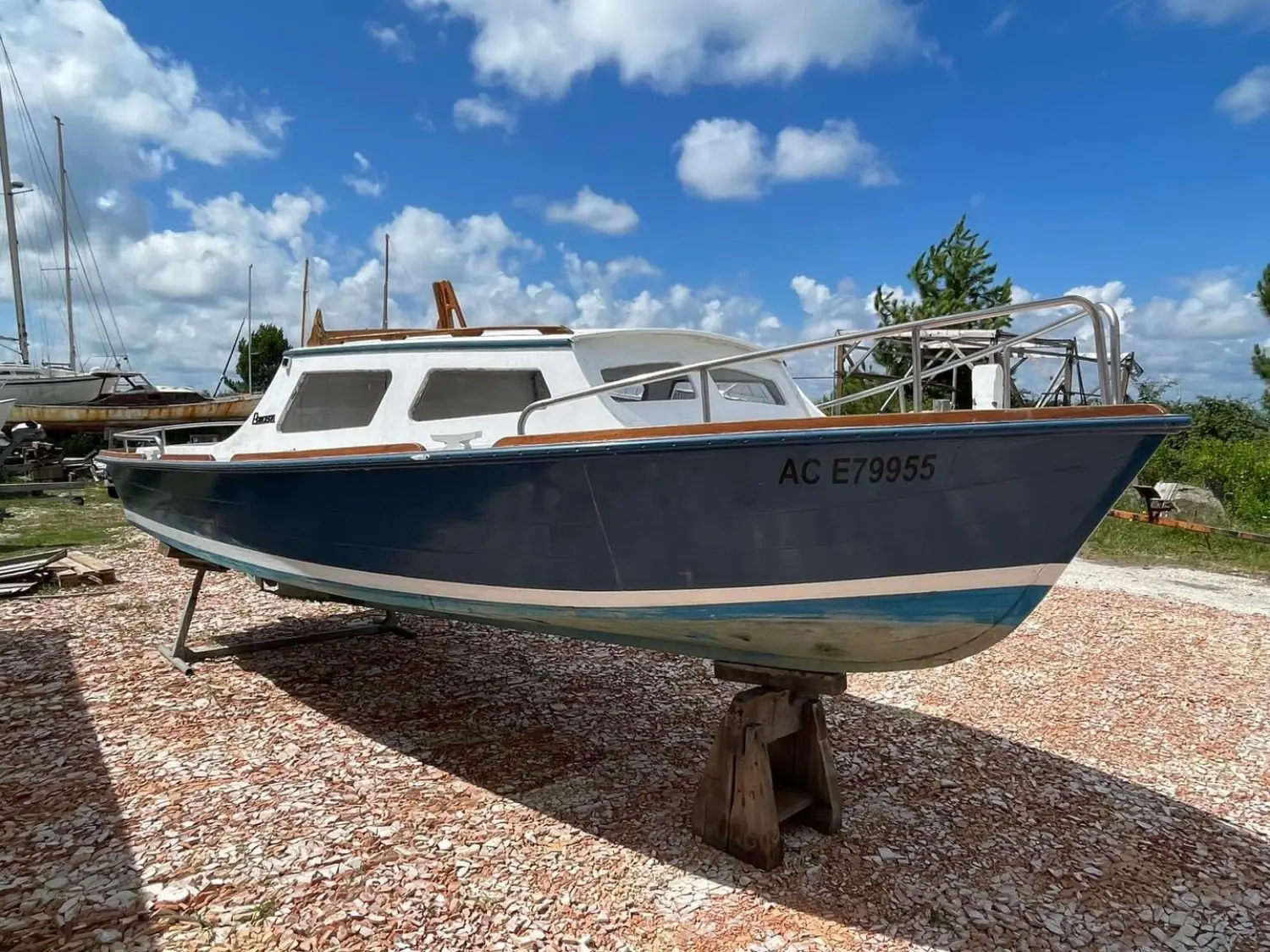 Pradere Arcachonnais — Bateau à cabine bleu et blanc photographié à terre, vu de trois quarts.