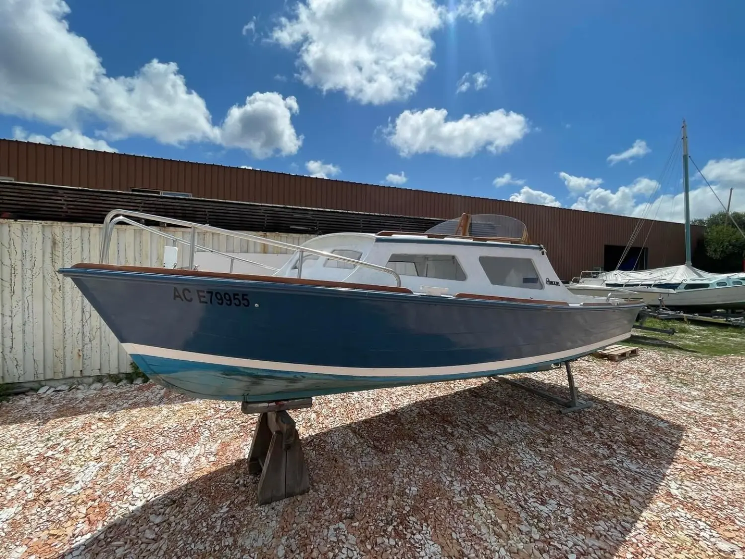 Pradere Arcachonnais — Bateau à cabine bleu et blanc photographié de trois-quarts sur sa remorque.