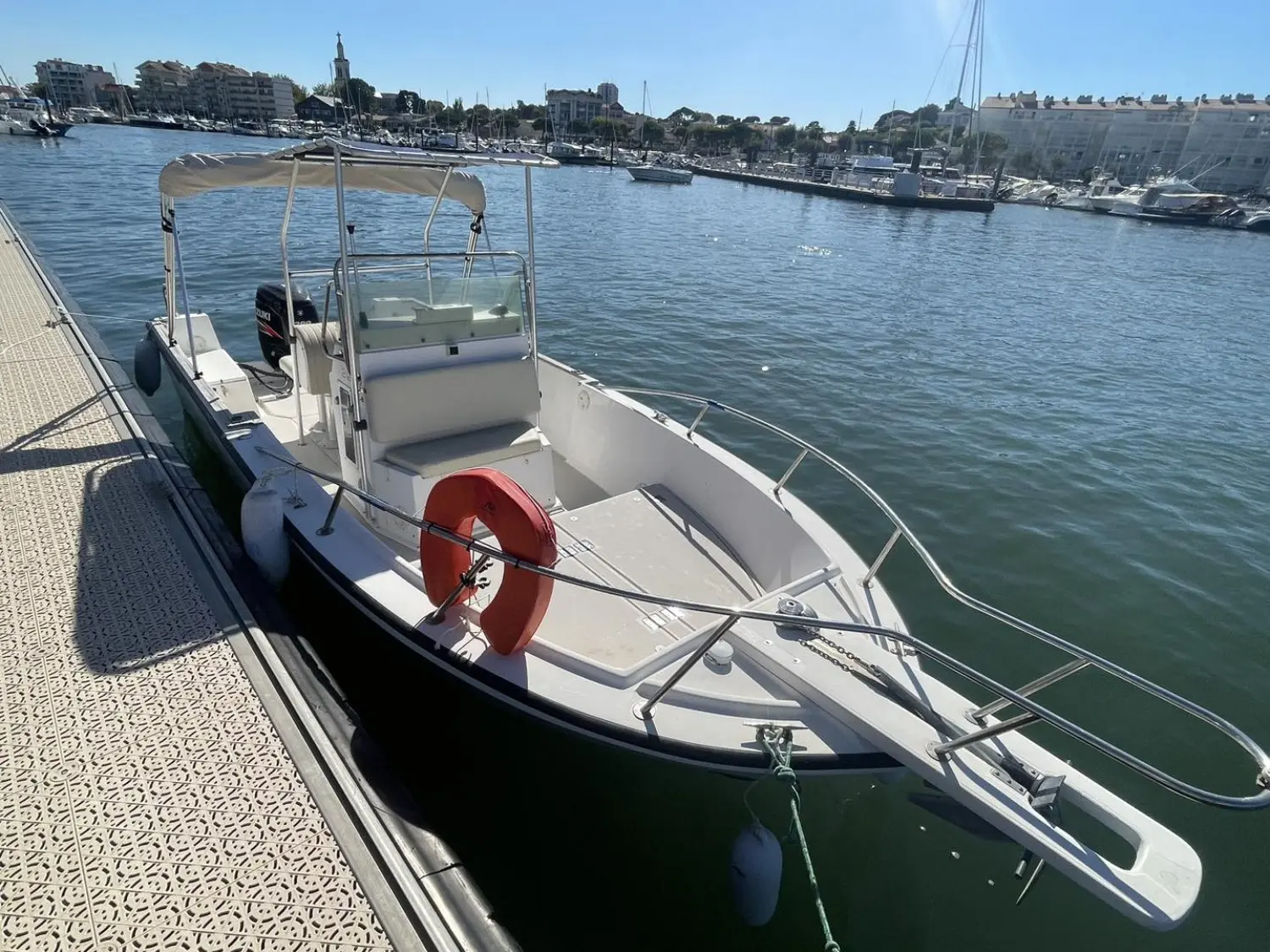 Robalo 2120 — Bateau à moteur blanc amarré à un ponton dans une marina.