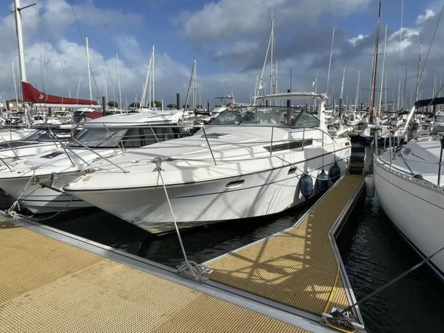 Yachting France Arcoa 975 — Bateau à moteur blanc amarré dans une marina, vu de trois quarts avant.
