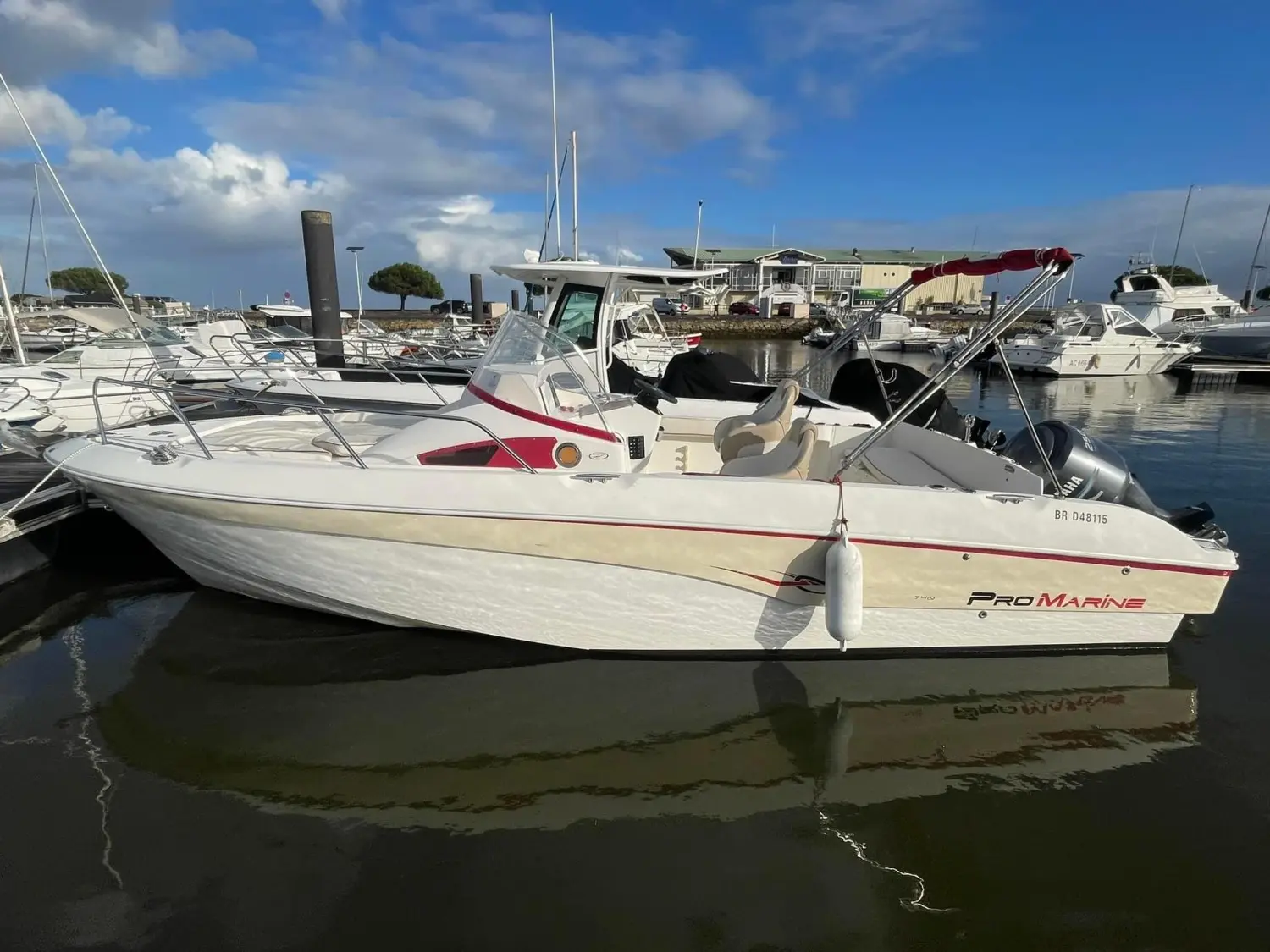 Pro Marine Belone 740 — Bateau à moteur blanc amarré dans une marina, vu de profil.