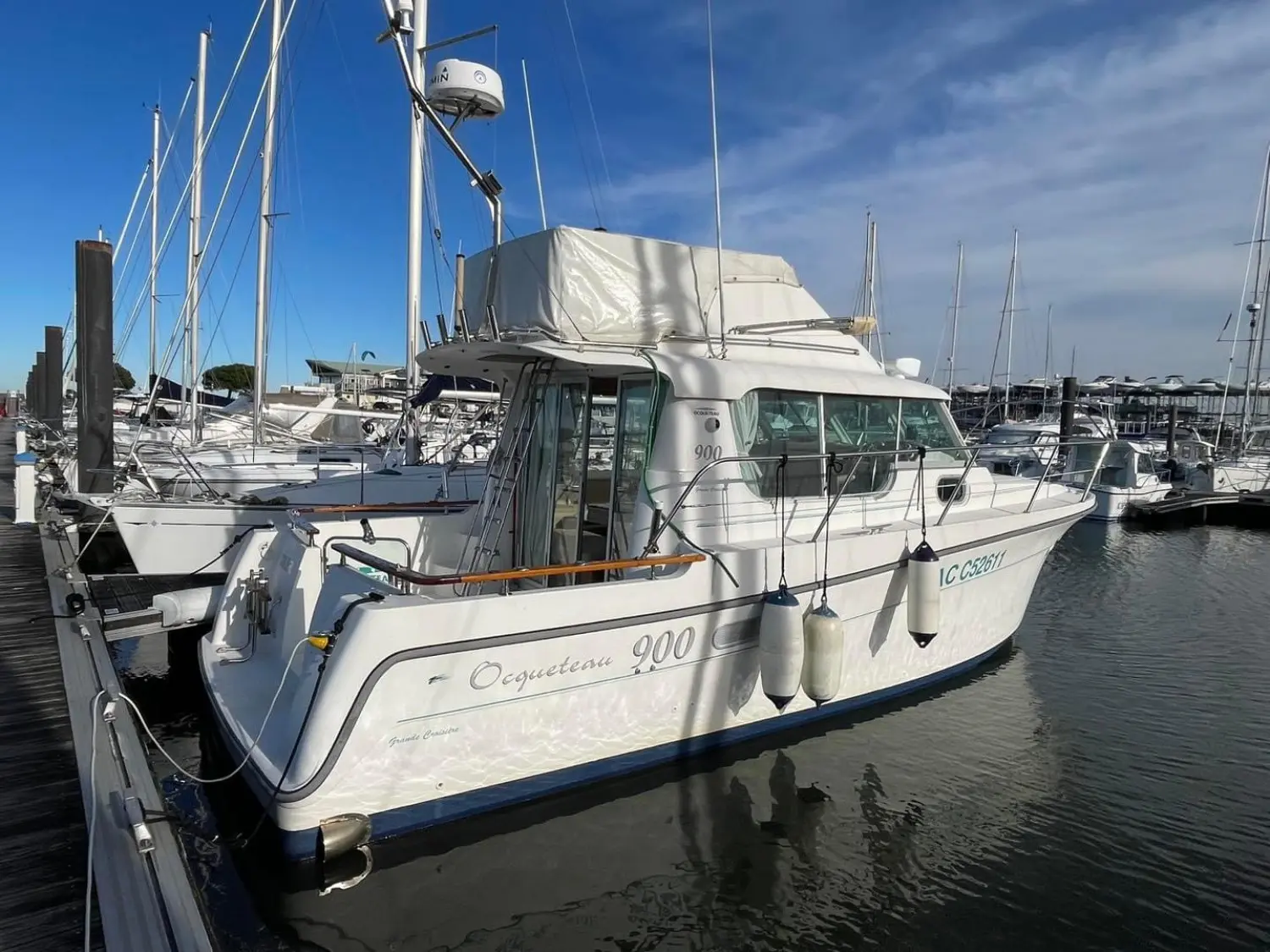 Ocqueteau 900 — Vedette Ocqueteau 900 amarrée dans un port, vue en trois quarts arrière.