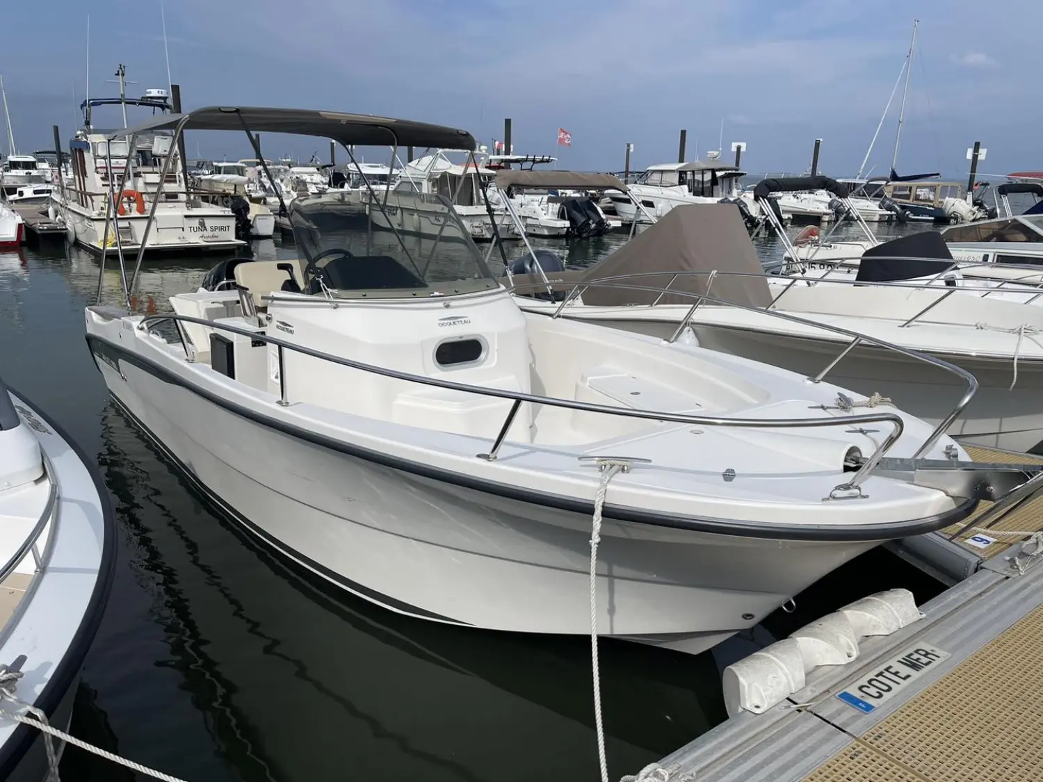 Ocqueteau Abaco 800 Open CC — Bateau à moteur blanc amarré dans un port, vu de trois quarts avant.